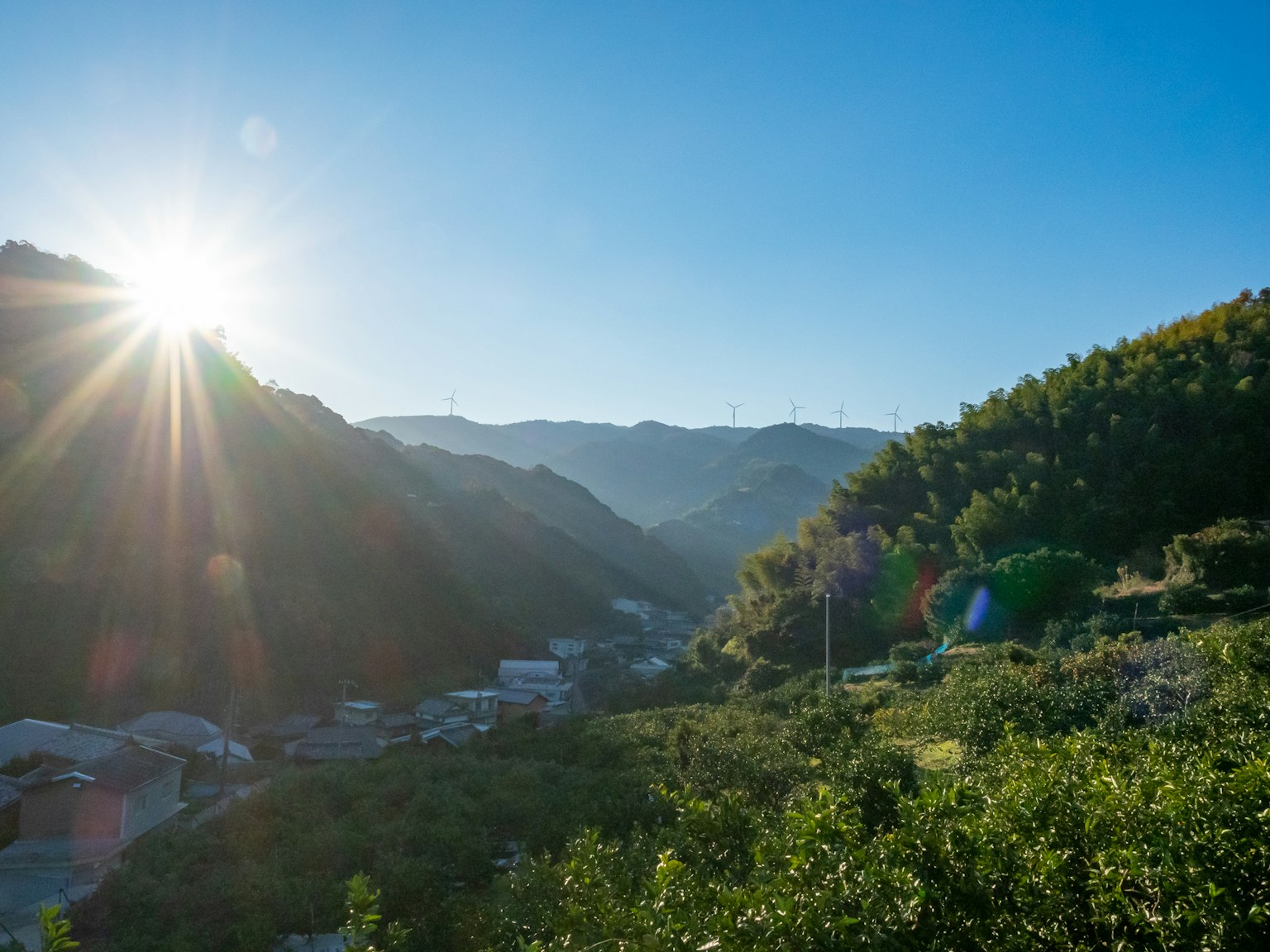 Paysage montagneux pittoresque avec un soleil brillant dans un ciel bleu clair