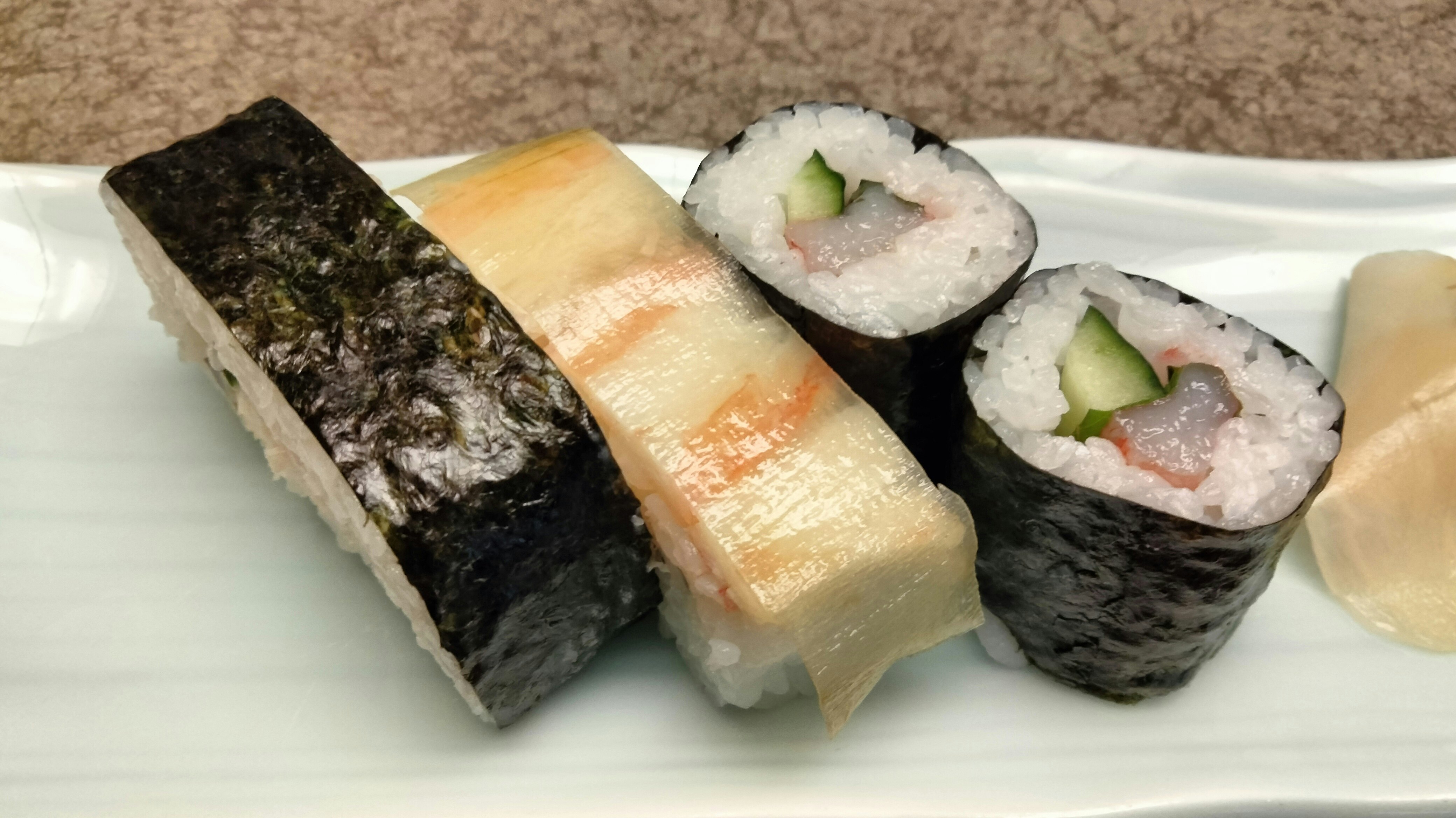 白い皿に並ぶ寿司ロールと握り