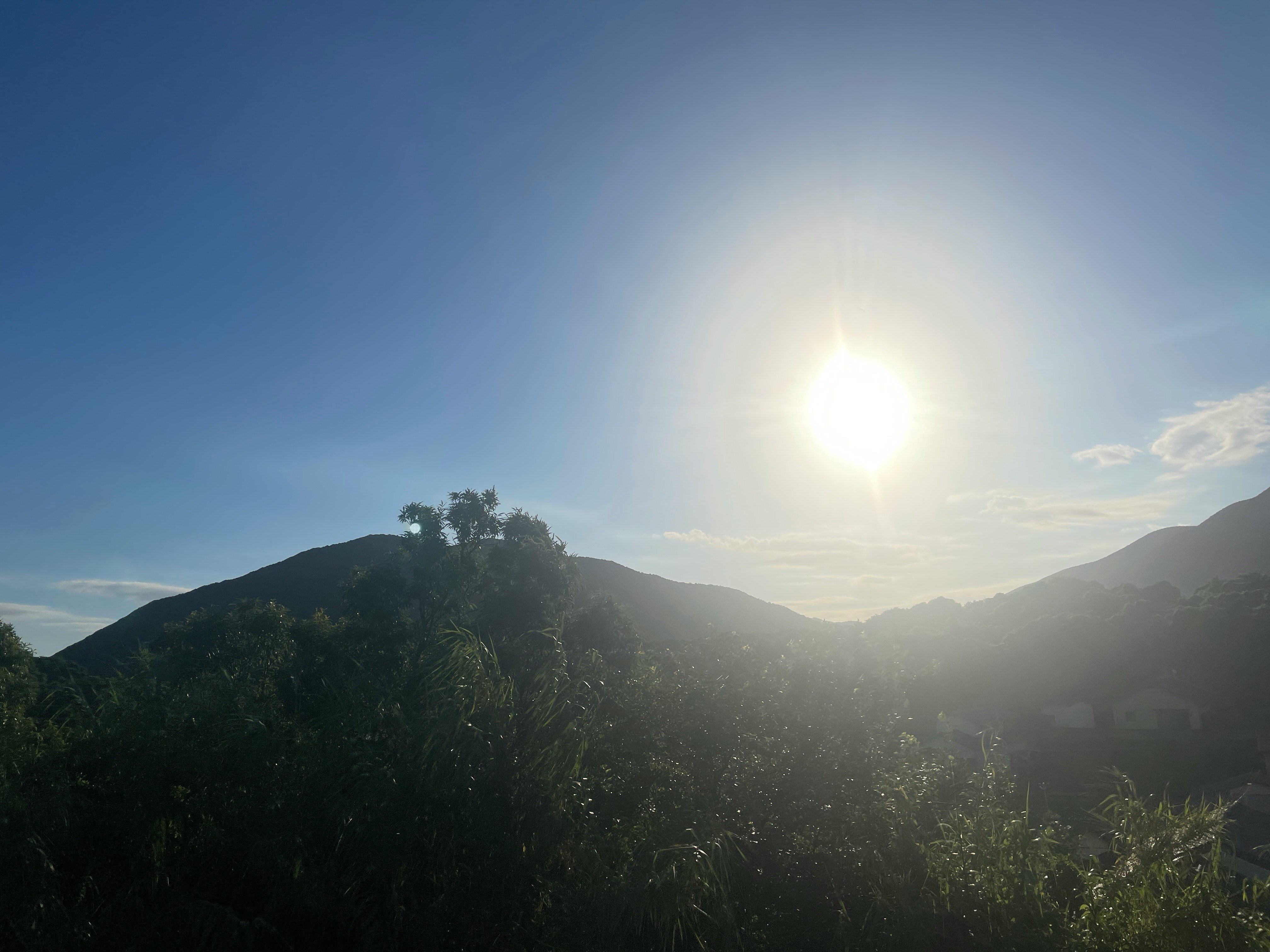 朝日が差し込む山並みと緑の稜線