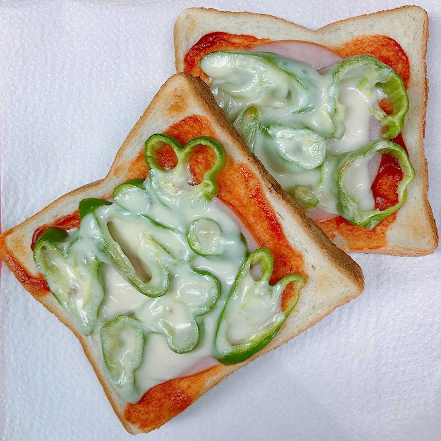 토스트 위에 초록 피망과 치즈가 얹혀진 요리