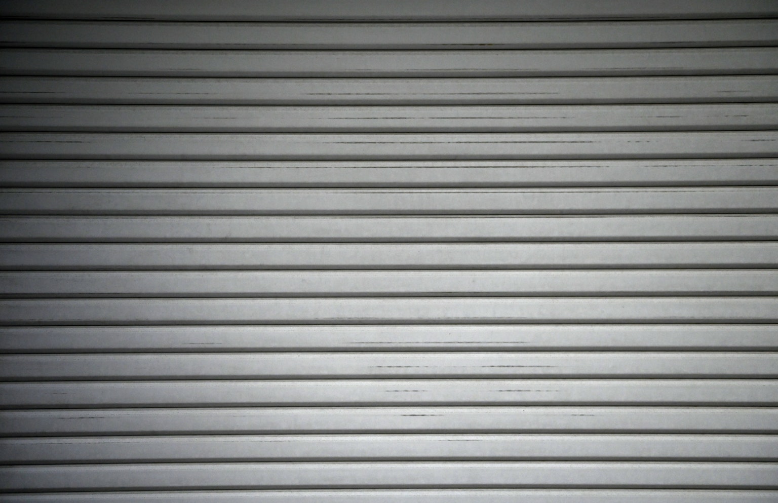 Volet roulant en métal gris avec des rayures horizontales