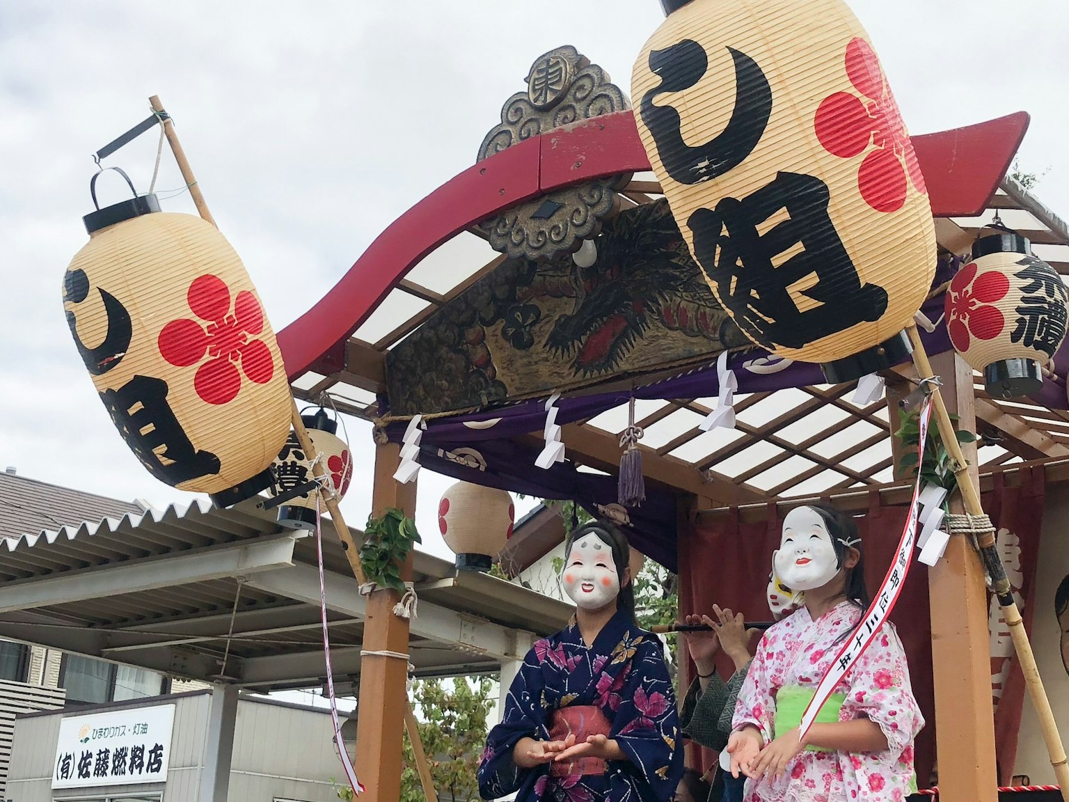 Two women in kimono standing on a festival float
