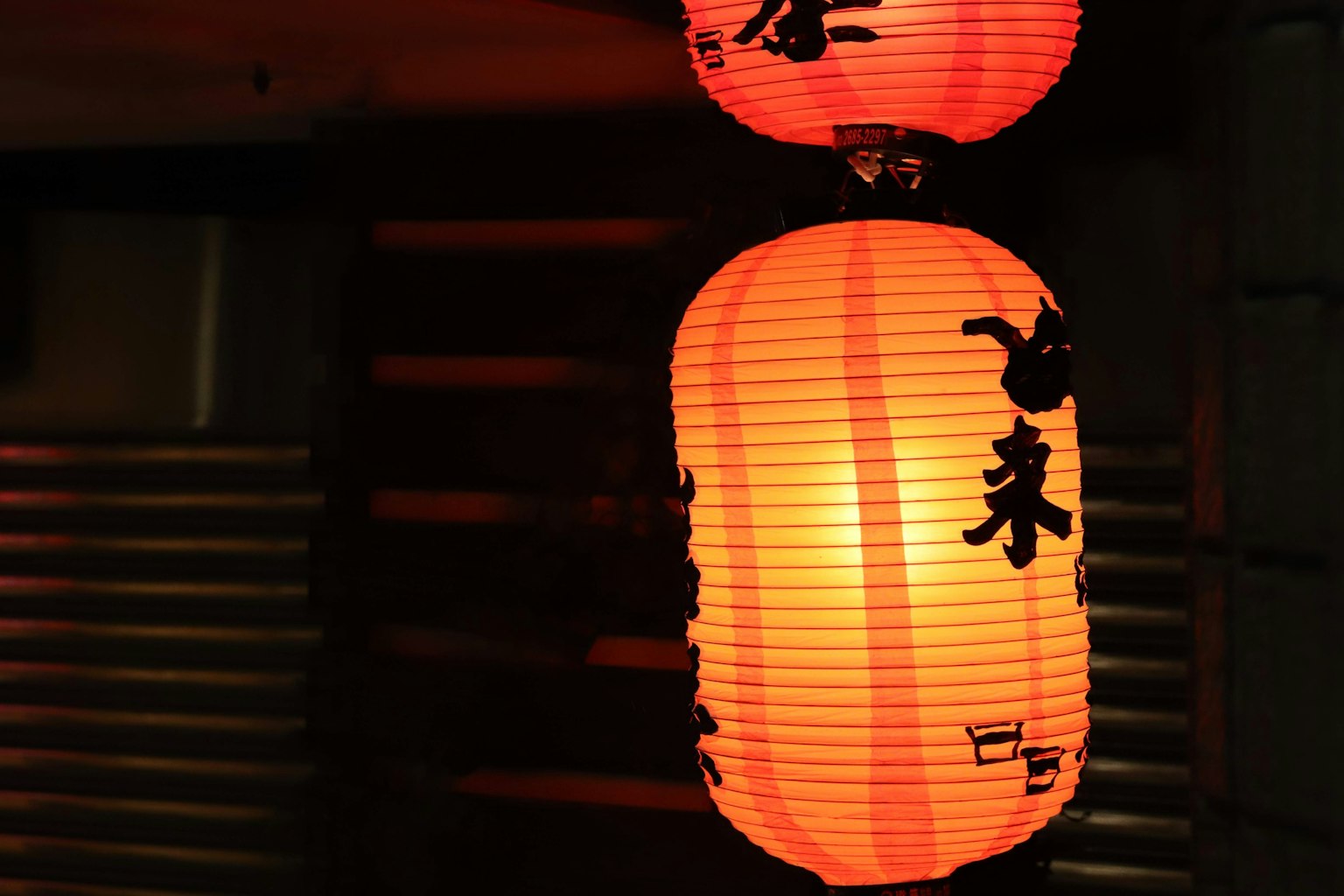 Lanternes rouges illuminées avec calligraphie noire