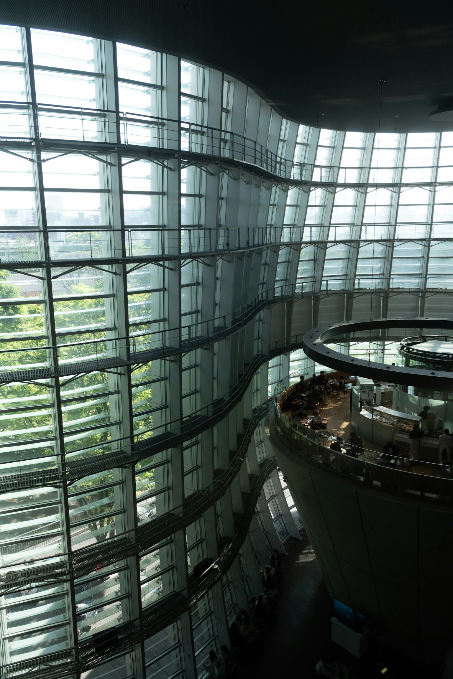 Interior bangunan modern dengan dinding kaca dan pemandangan hijau