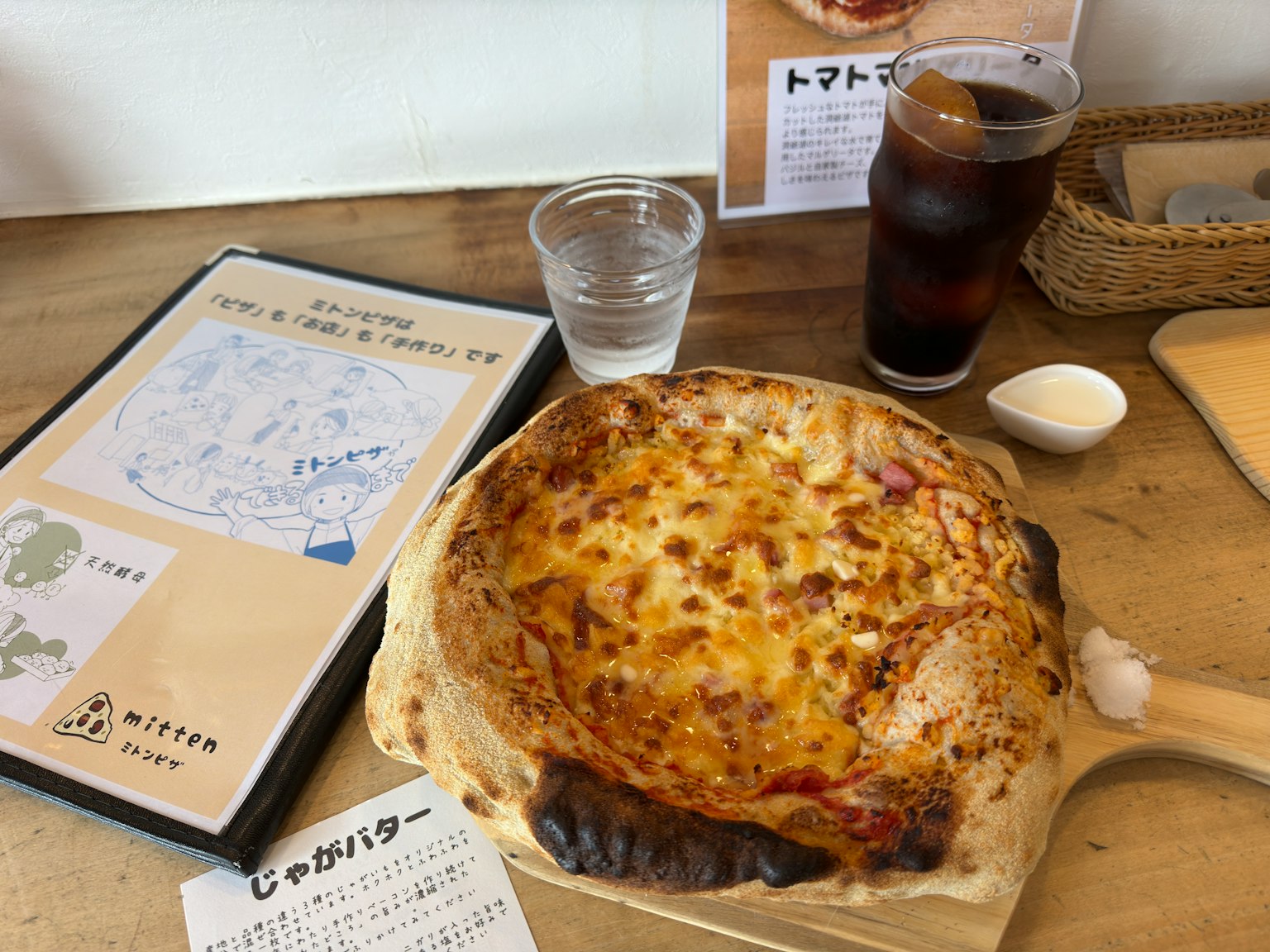 Frisch gebackene Pizza und Getränk auf einem Esstisch