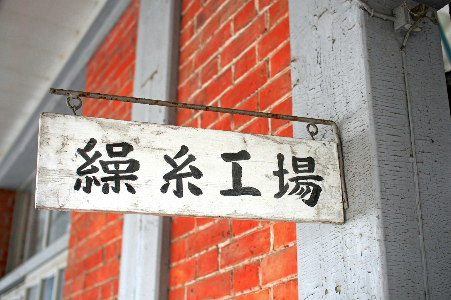 挂在红砖墙上的木牌，上面写着织布厂
