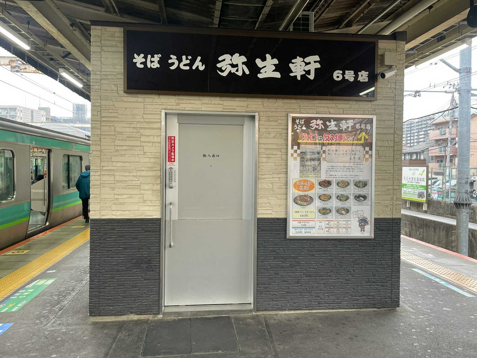 Vista esterna di un ristorante di soba alla stazione con menù
