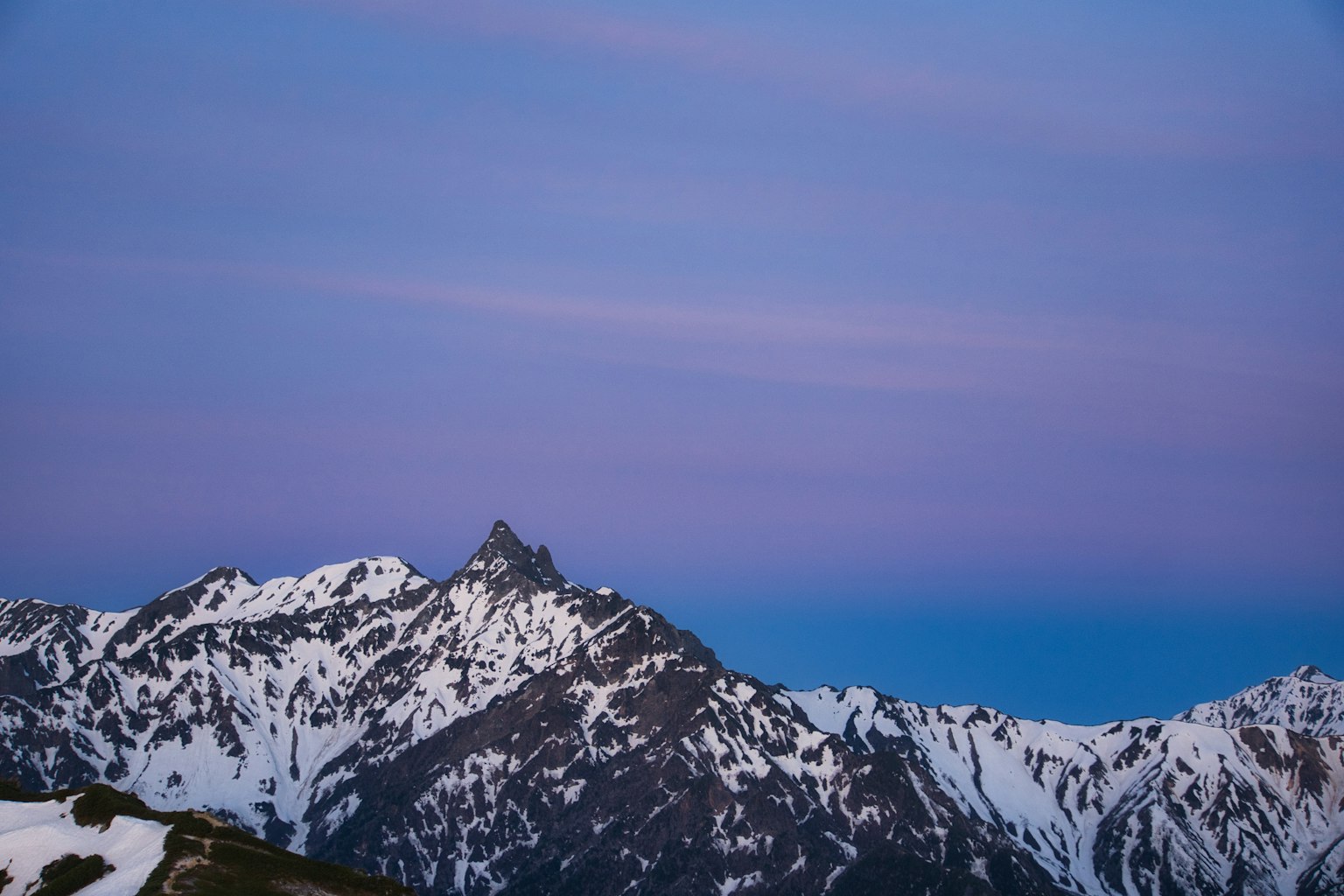 Montañas nevadas bajo un cielo púrpura