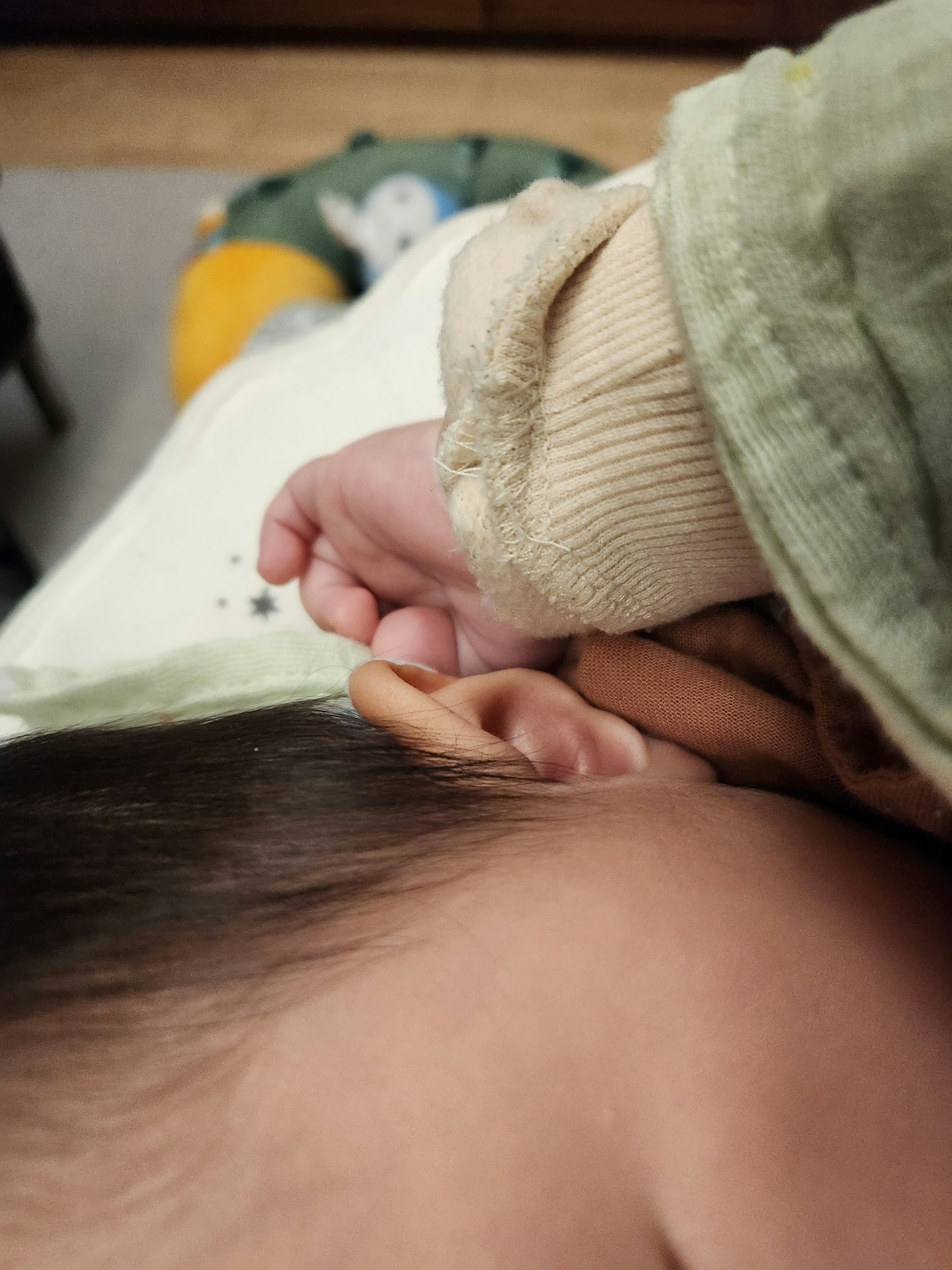 Une main de bébé touchant doucement une oreille