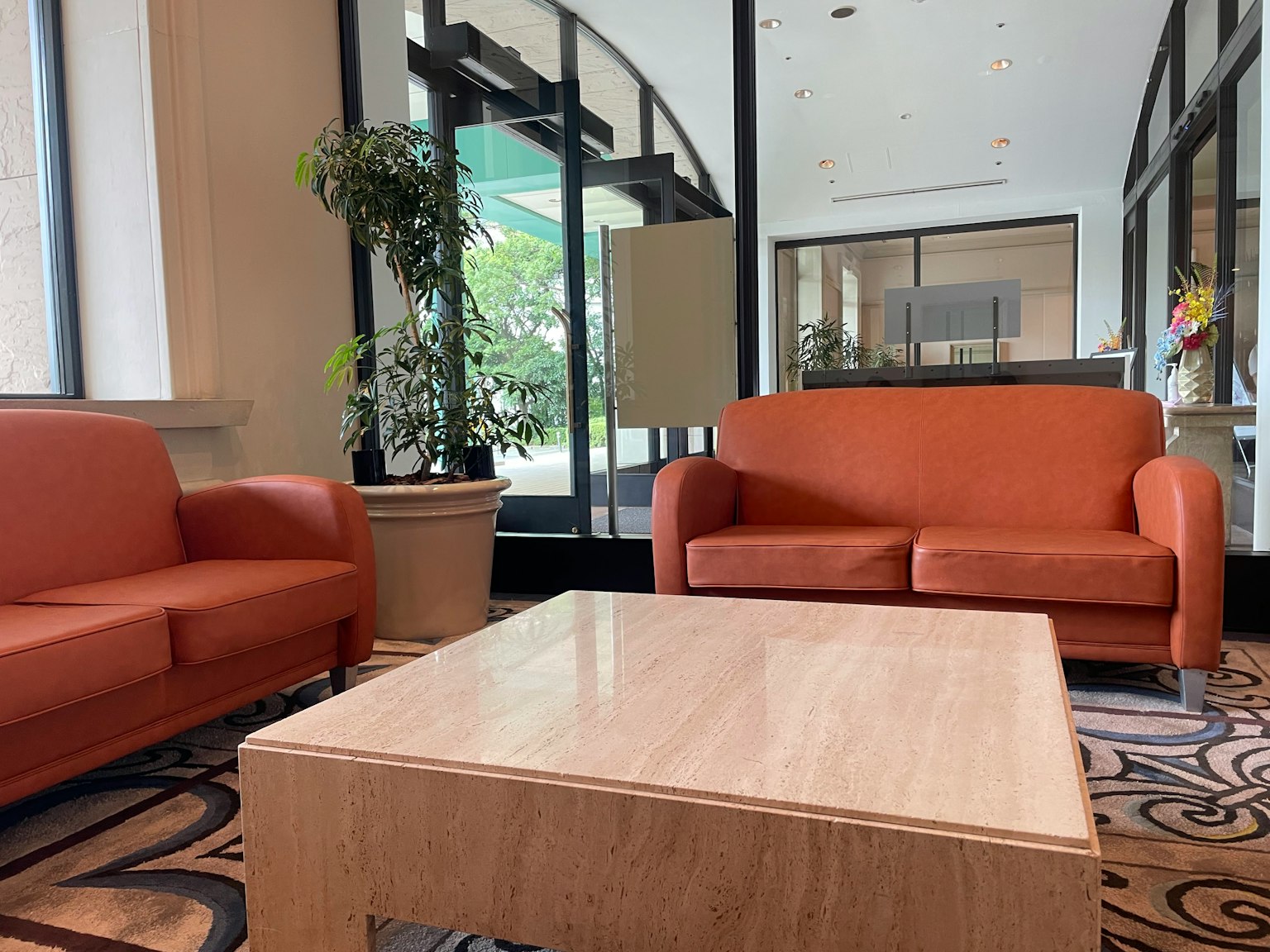Nội thất sảnh sáng với ghế sofa màu cam và bàn cà phê bằng gỗ