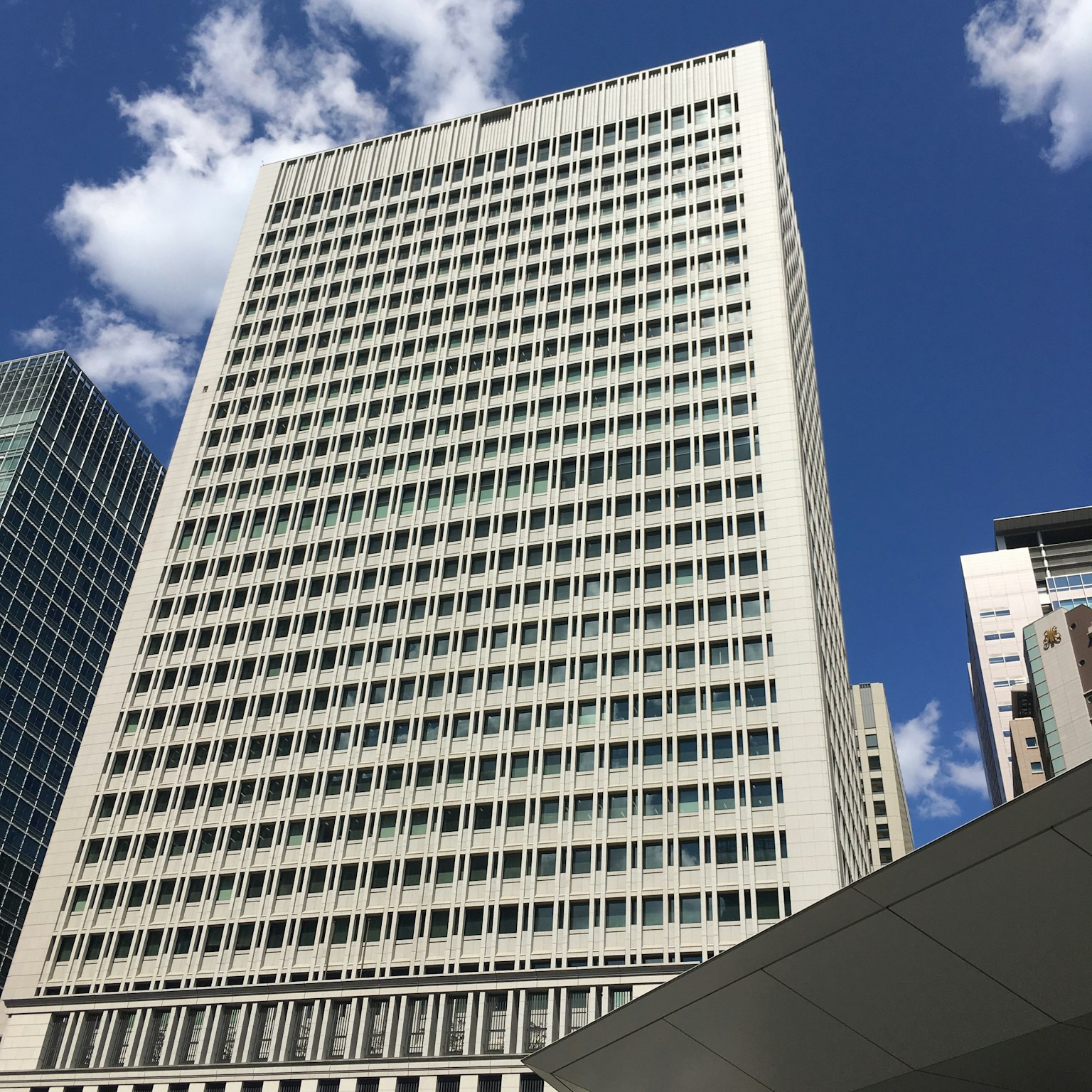 現代摩天大樓外觀，藍天白雲背景