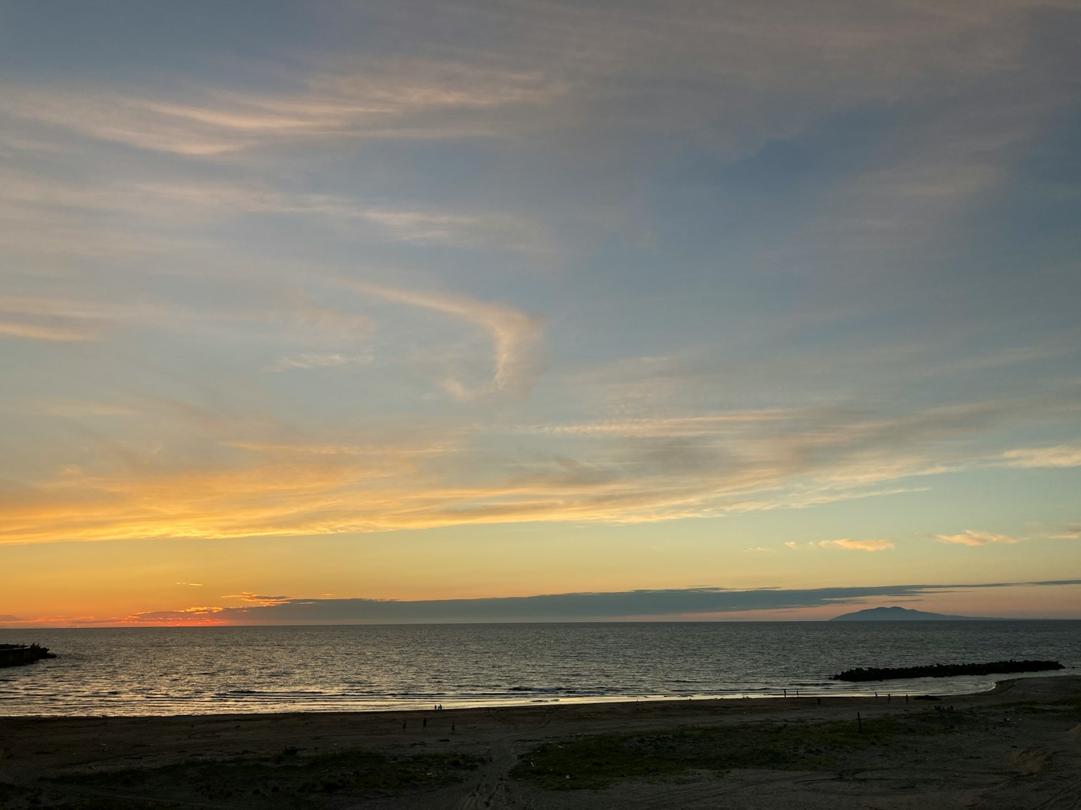 Paesaggio marino sereno con colori del tramonto e cielo nuvoloso