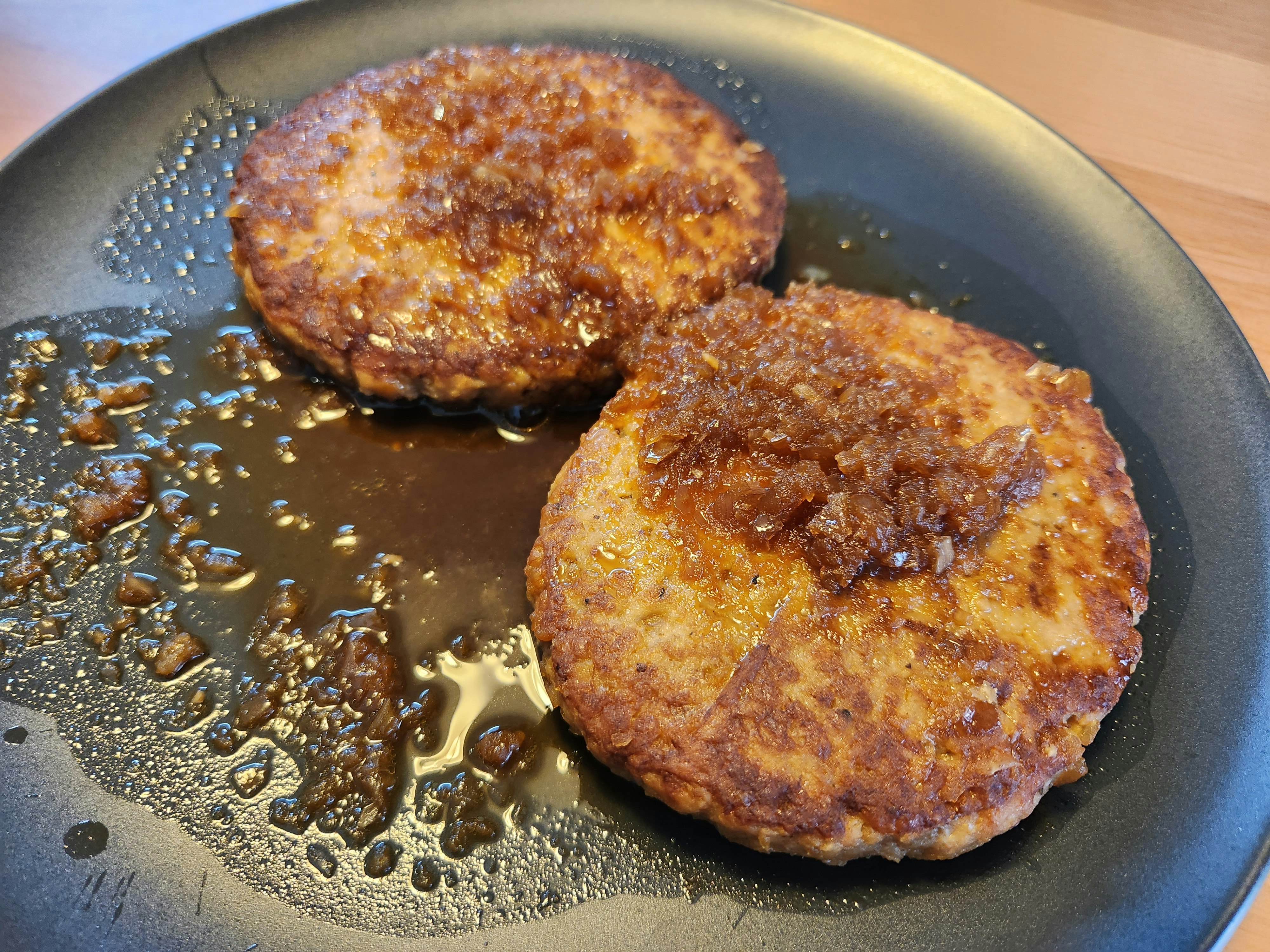 Sizzling hamburg patties in a frying pan