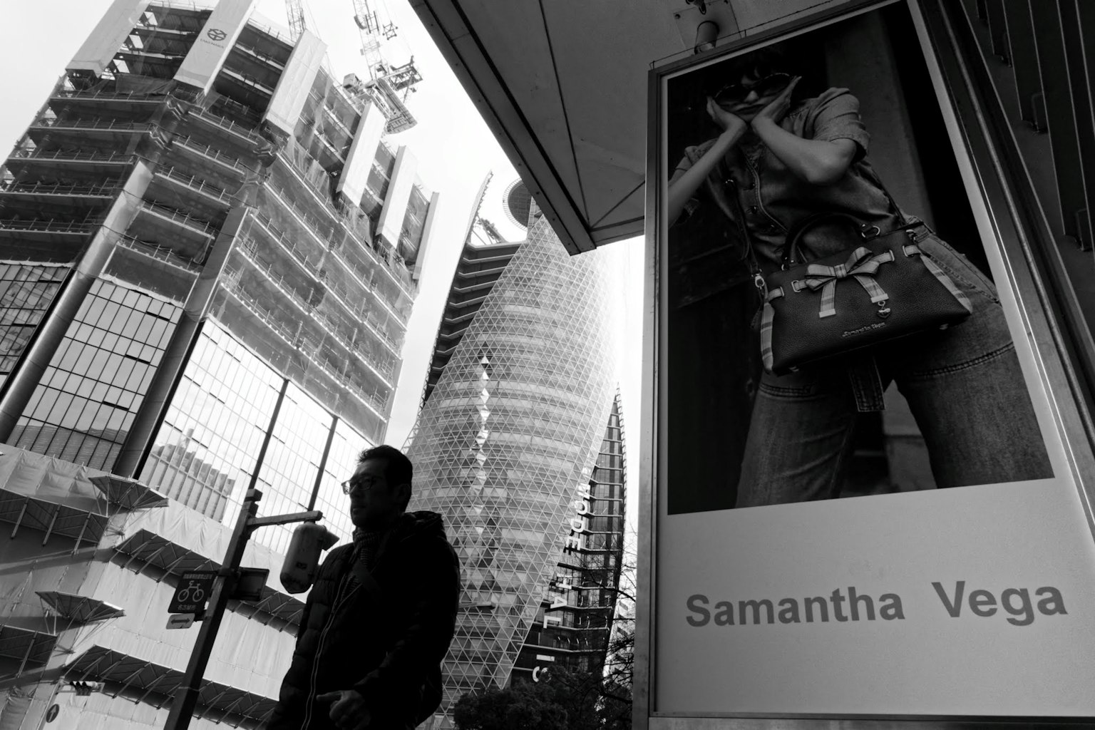 Scène urbaine avec une publicité de Samantha Vega et la silhouette noire d'une personne
