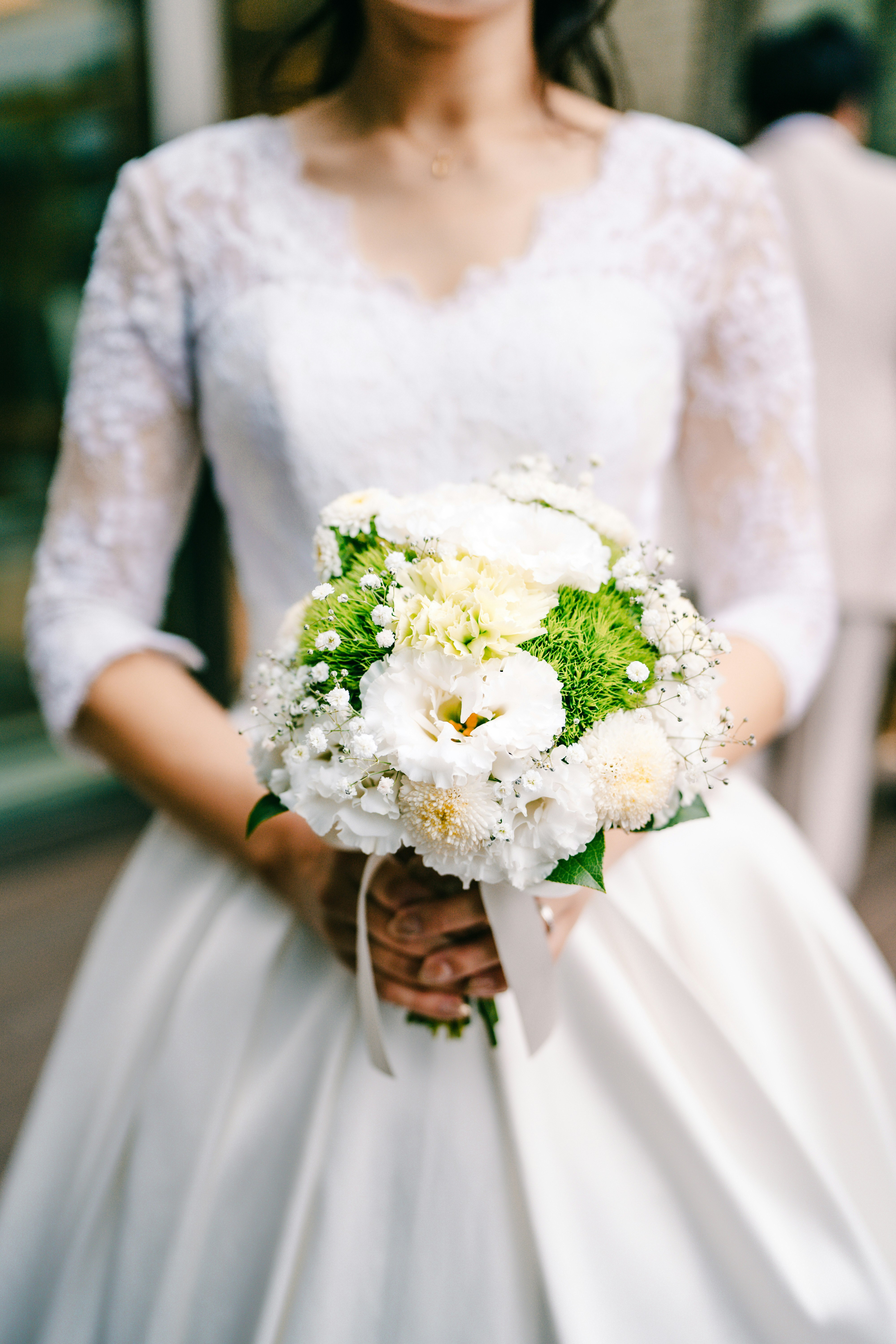 bride holding a white-and-green bouquet