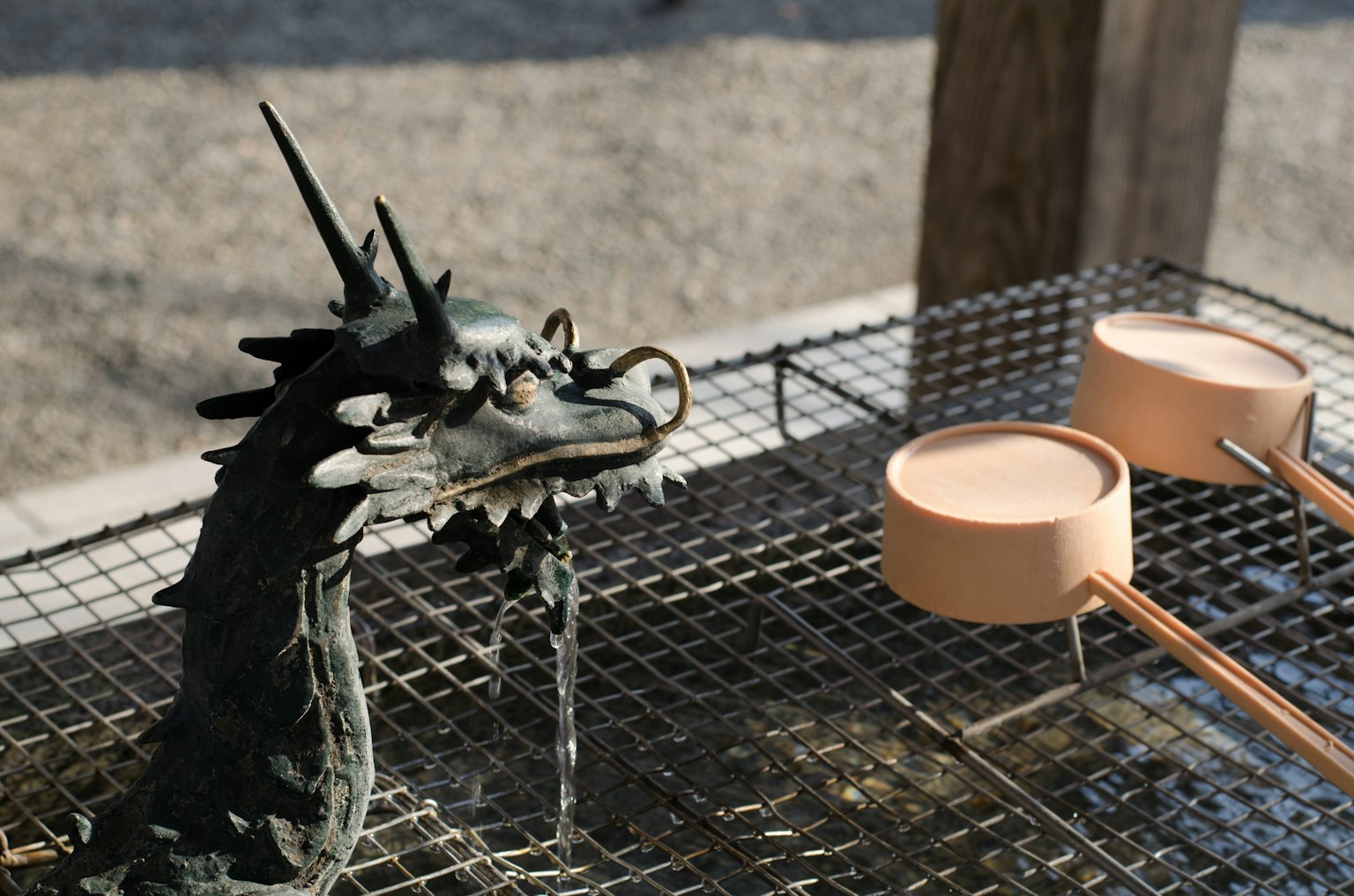 A dragon sculpture pouring water and wooden water ladles