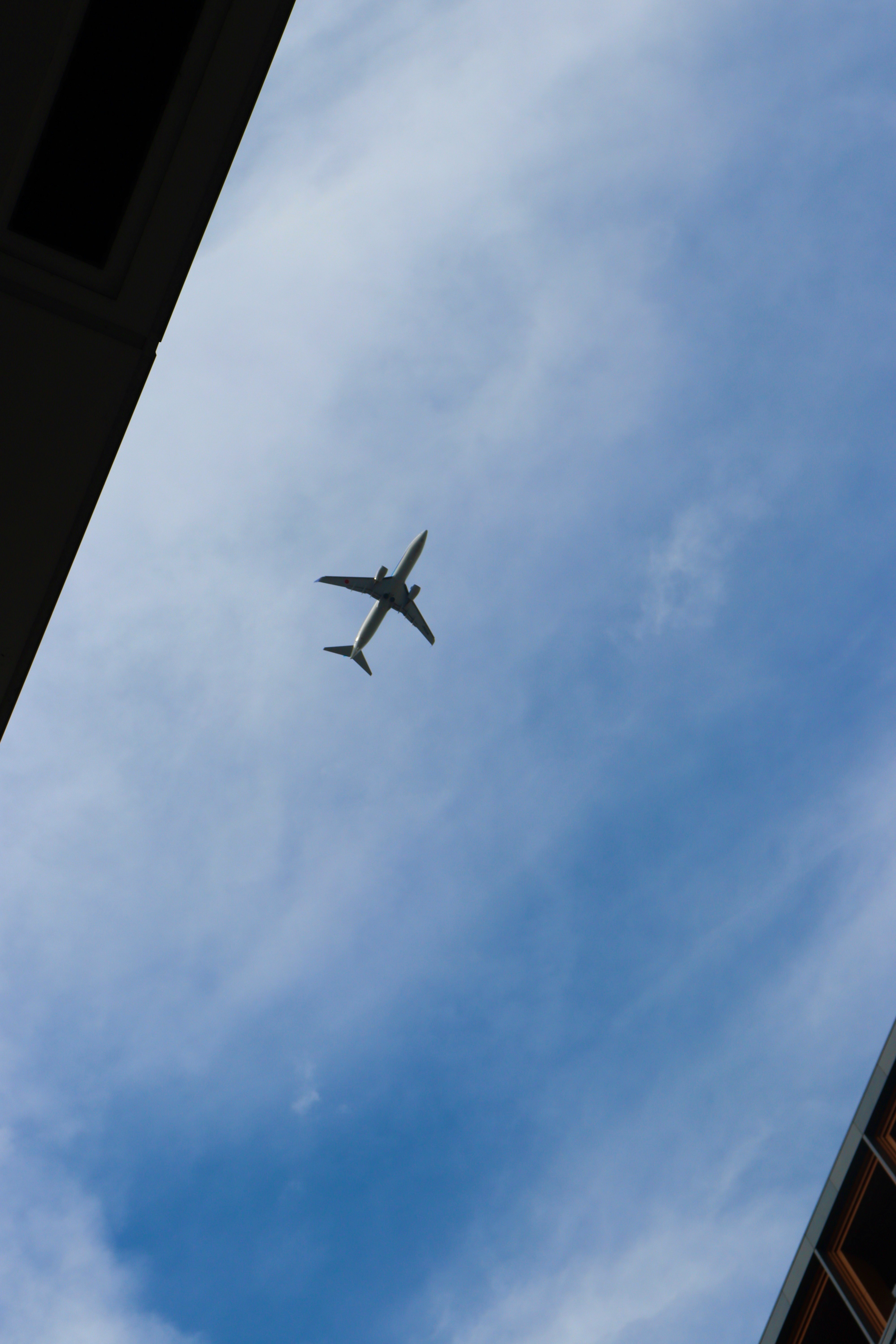 空に飛ぶ飛行機と雲のある青空
