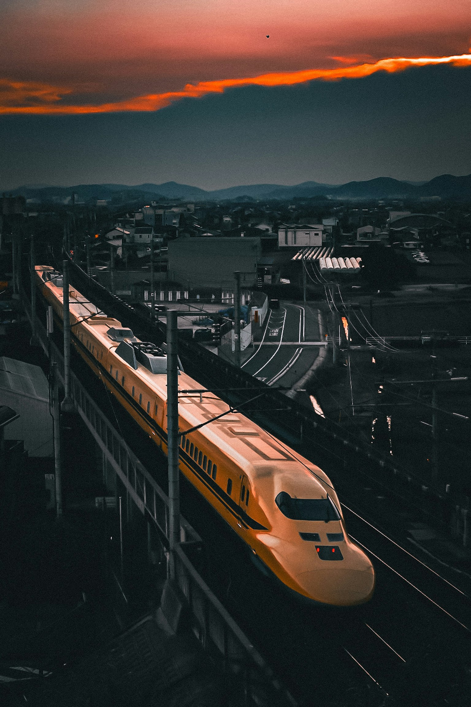 夕焼けの中を走る新幹線の高架線の風景