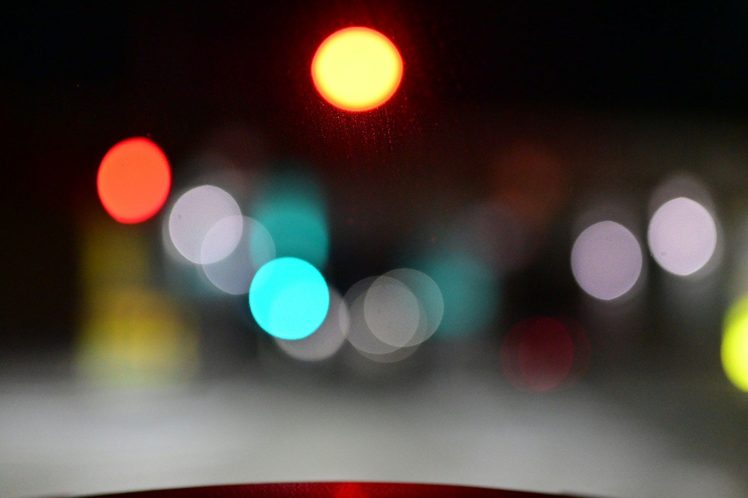 夜のぼやけた信号機の光と街の風景