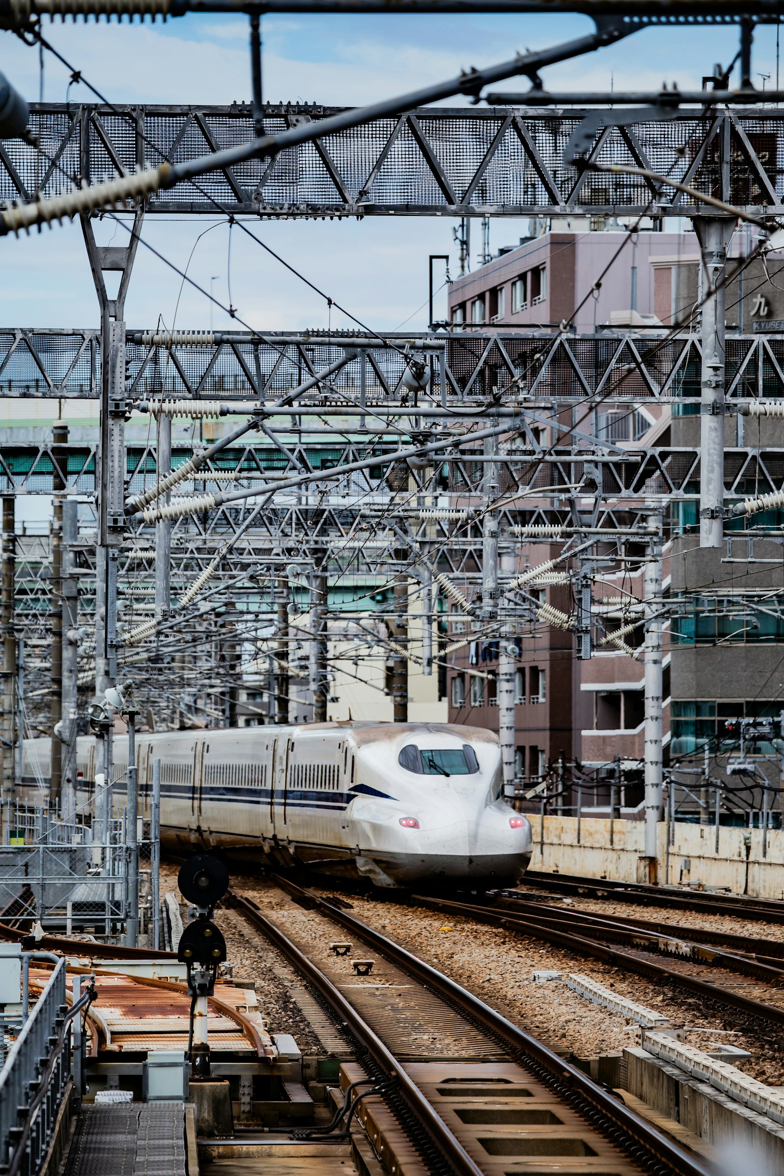 Train Shinkansen circulant sur des voies dans un environnement urbain