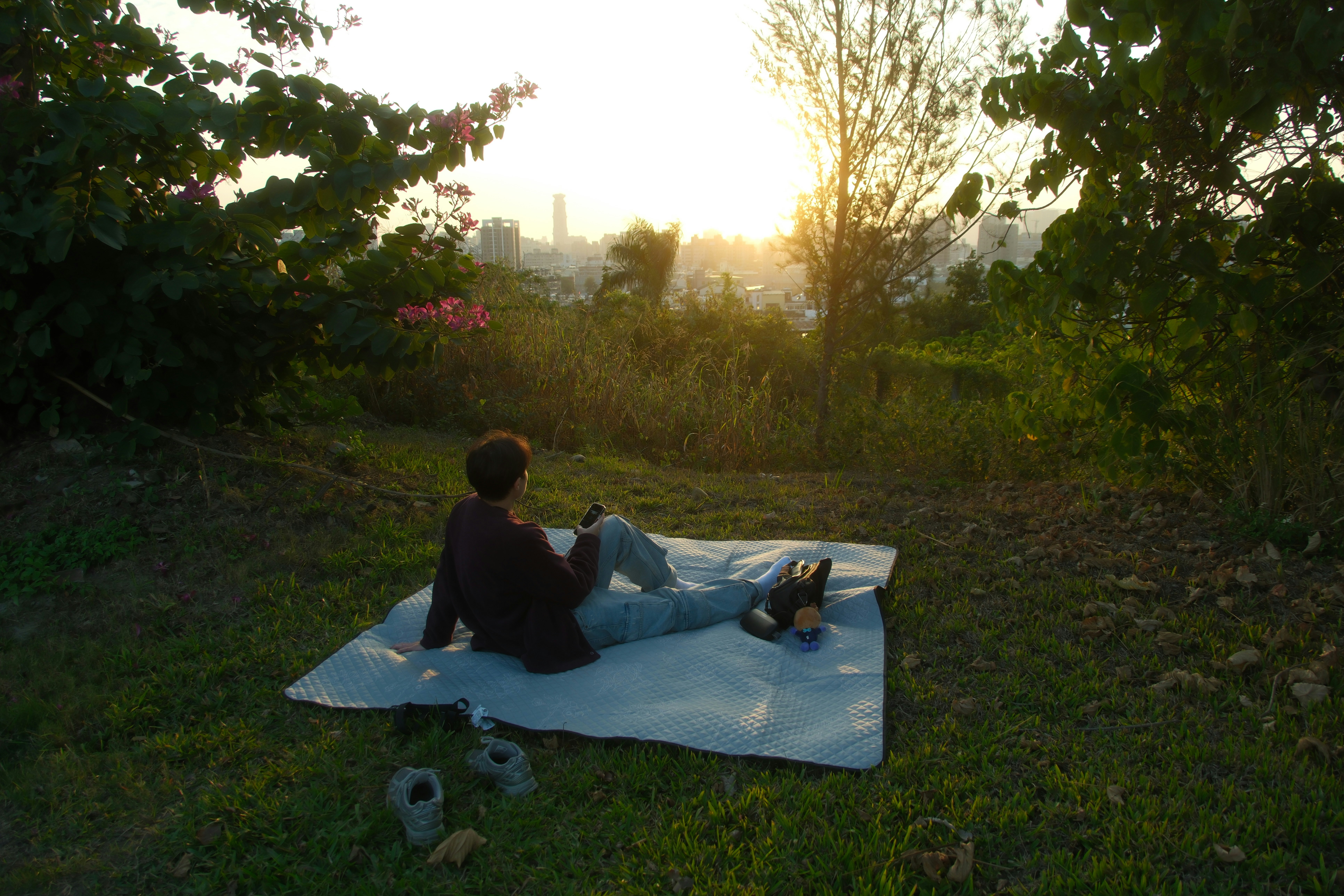 夕暮れの公園でレジャーシートに座る親子