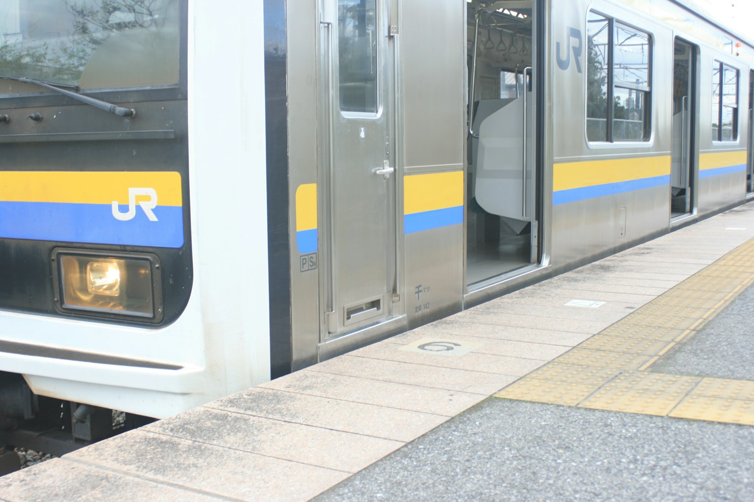 JR train stopped at a station with an open door