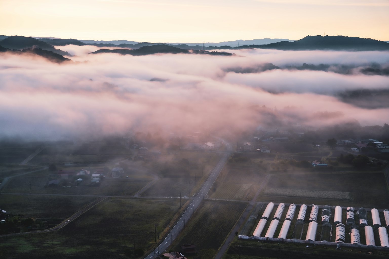 霧氣籠罩的風景鳥瞰圖與柔和的晨光