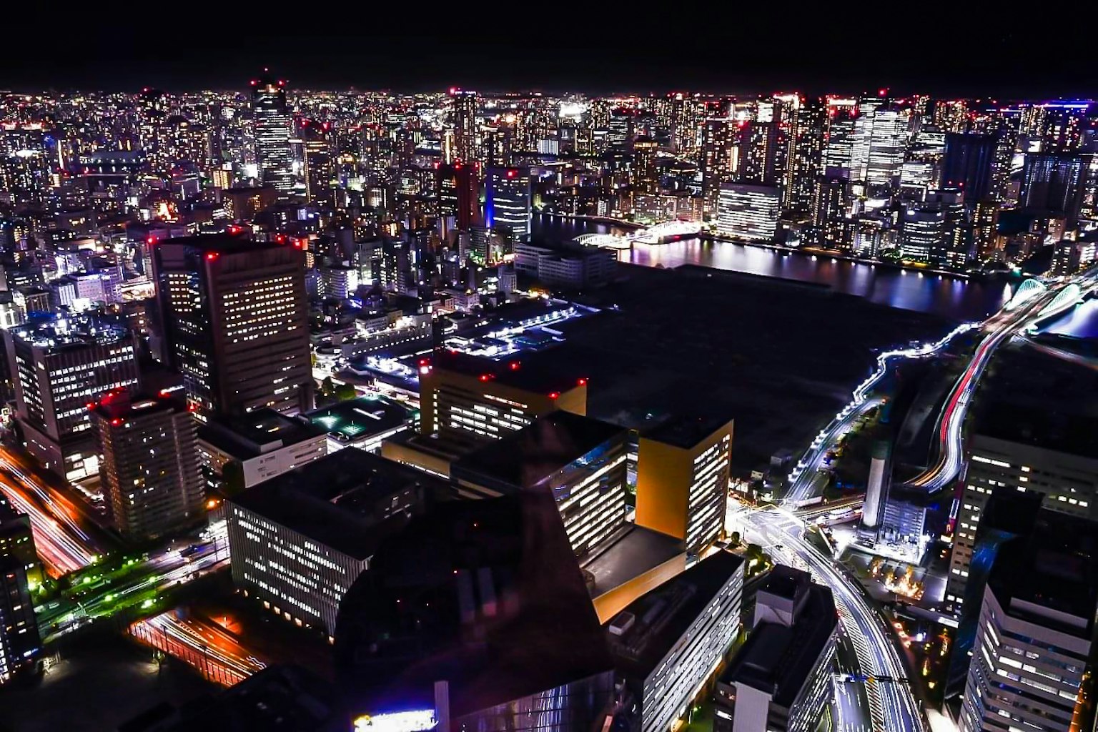 Splendida vista della città di notte con grattacieli illuminati e un fiume