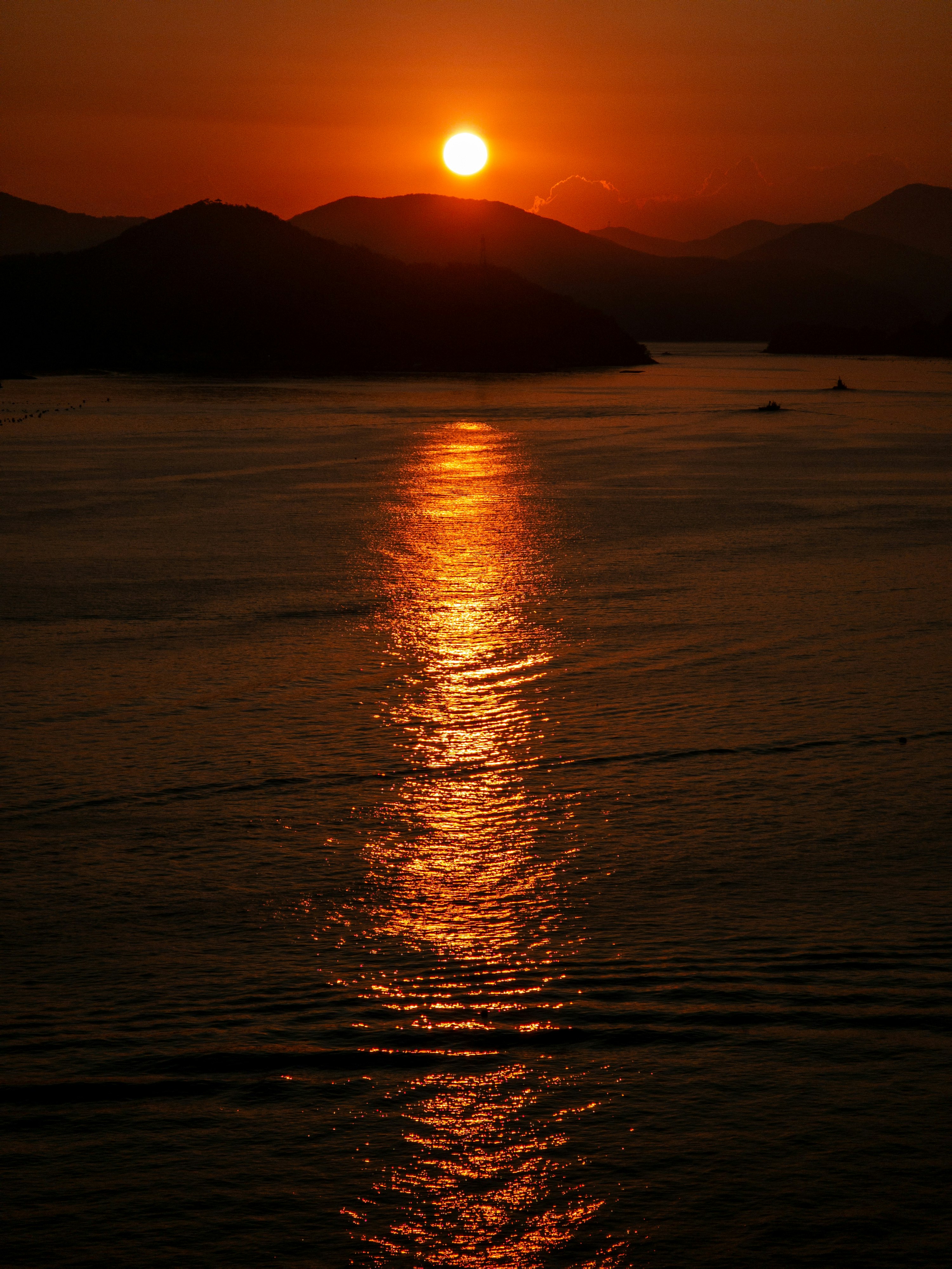 夕日に照らされる海岸の波と水平線