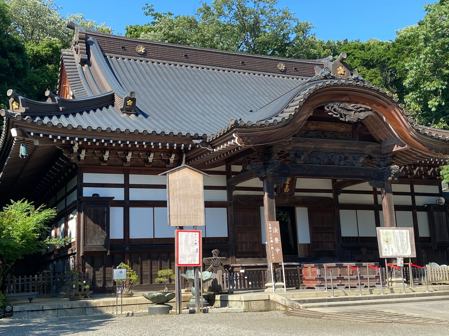 Traditional Japanese temple building with a beautiful roof and wooden structure surrounded by lush greenery