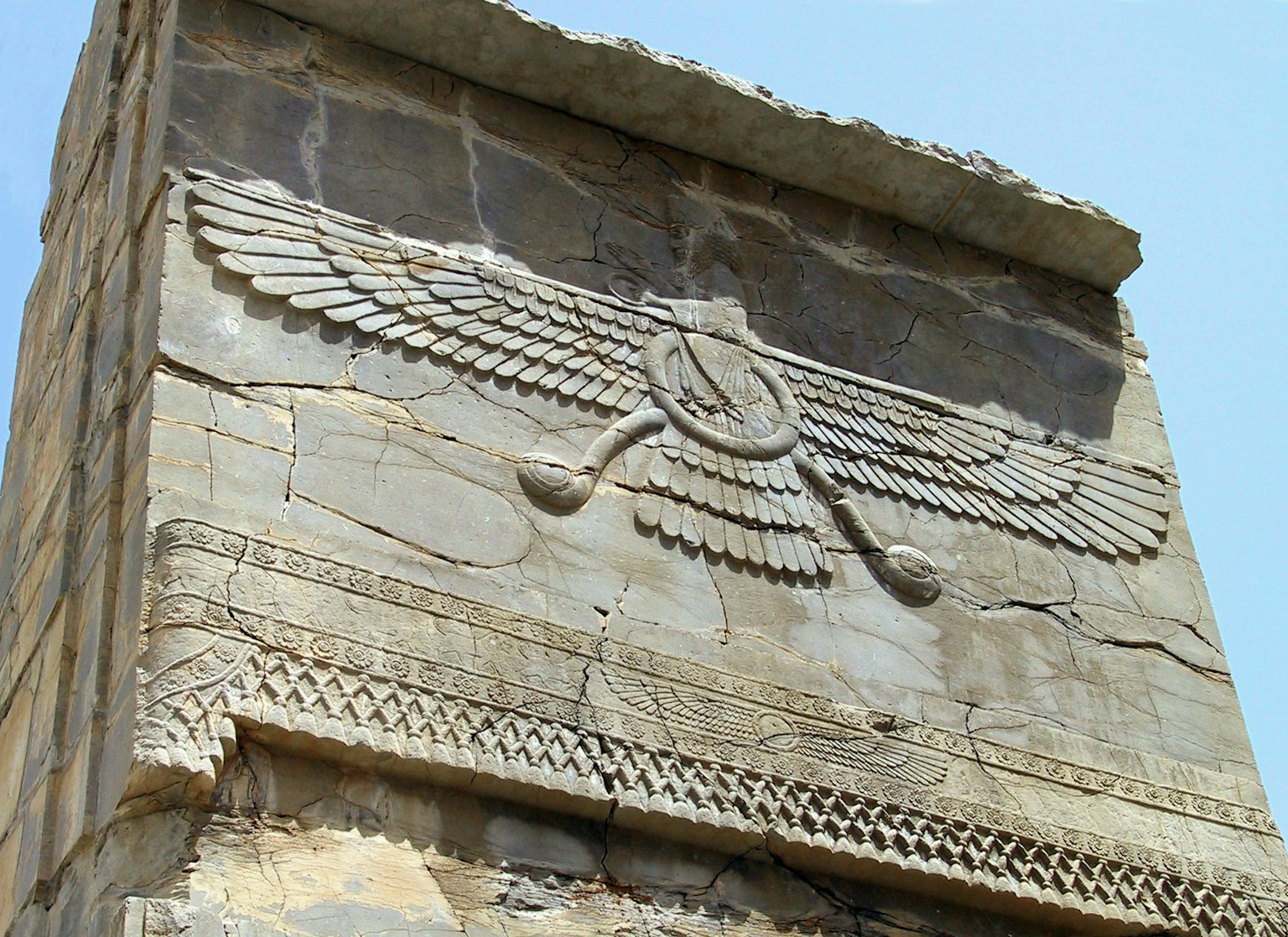 Ancient Persian stone wall featuring a carved winged symbol