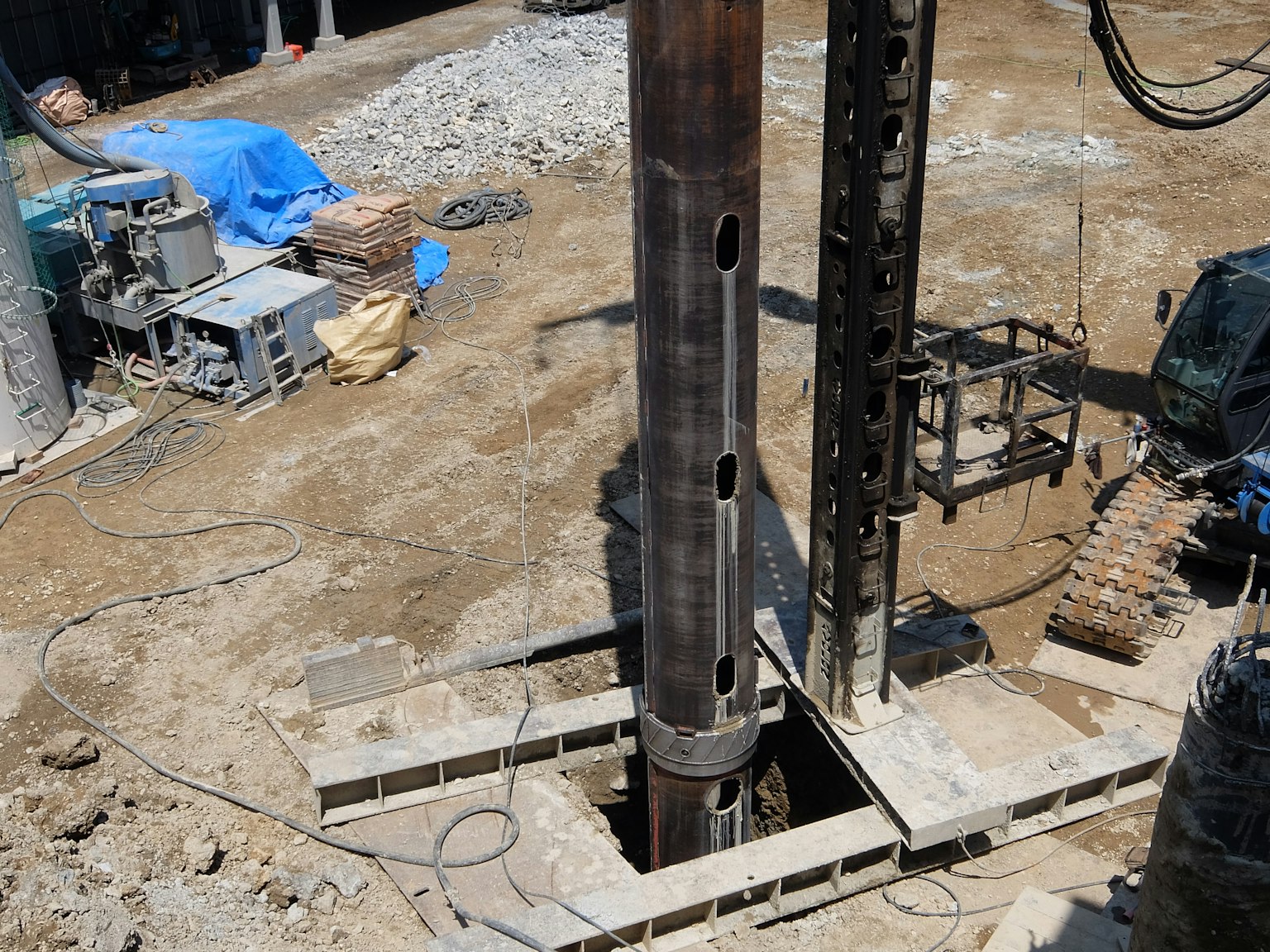 Large metal pipes standing in a deep hole at a construction site
