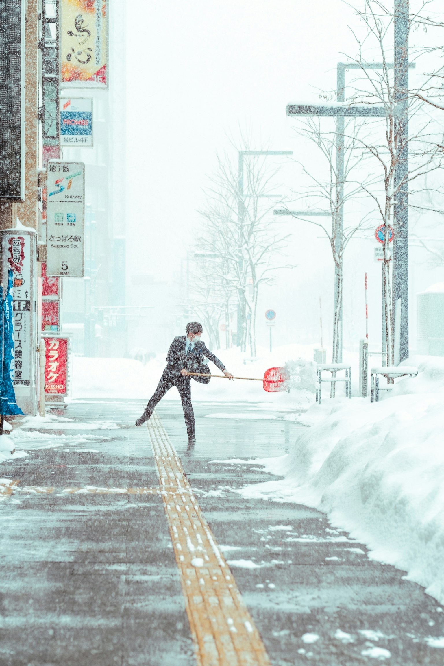 Person walking in snow with snowy surroundings and city signs