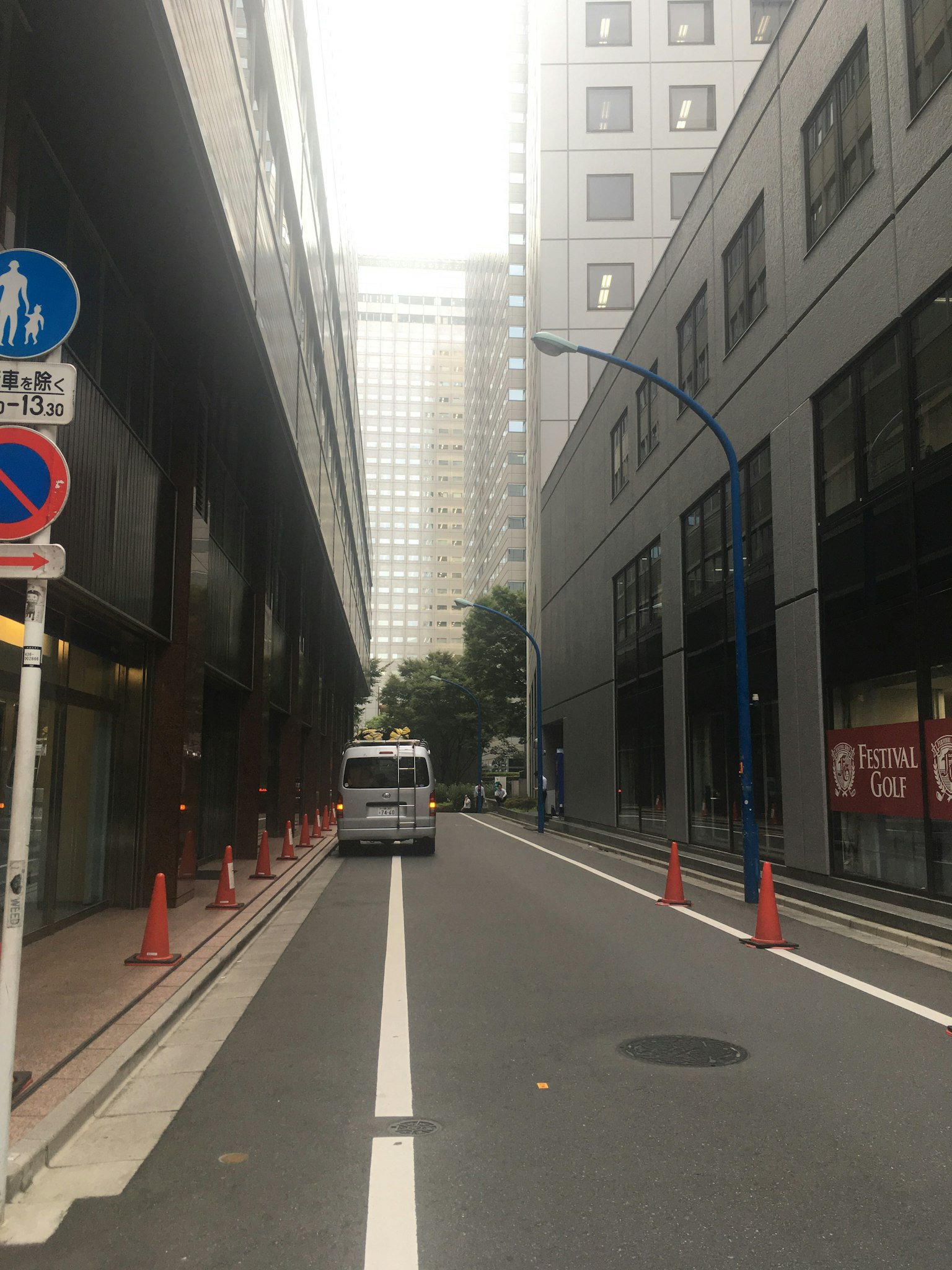 Narrow street flanked by buildings with parking signs in an urban setting