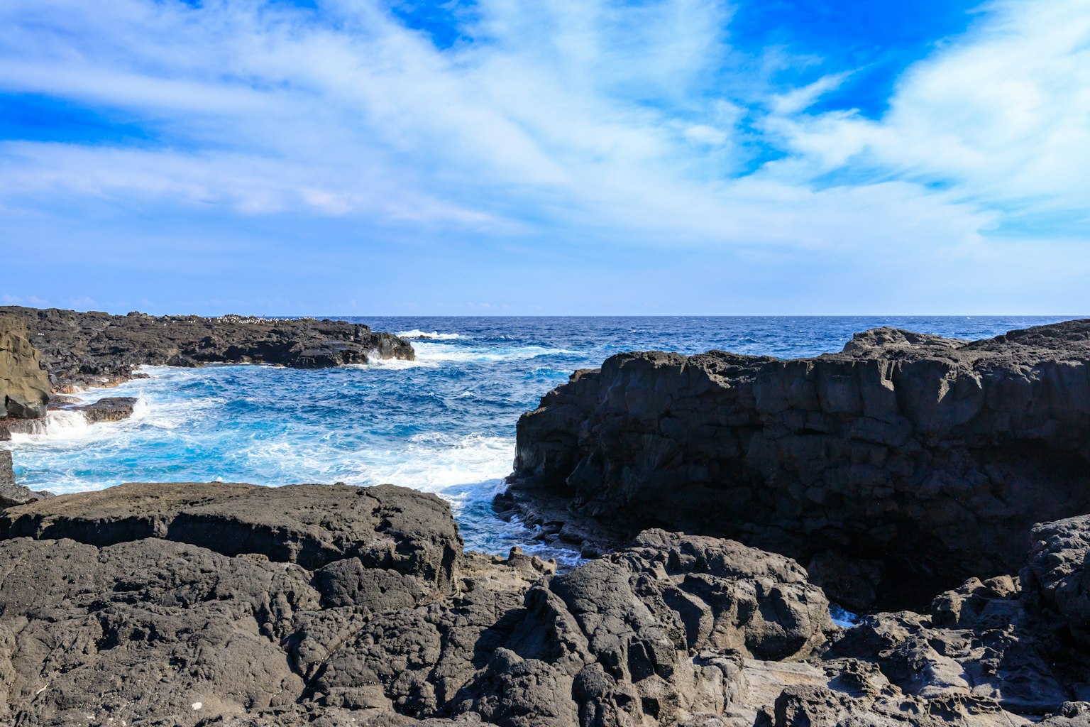 Vista escénica de la costa rocosa con cielo azul y olas del océano