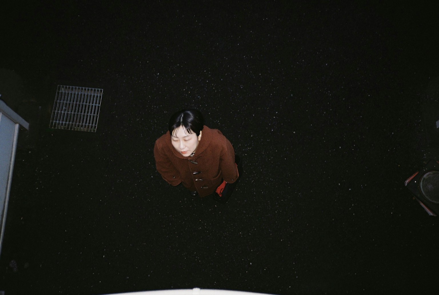 上から見た女性が暗い背景の中で立っている