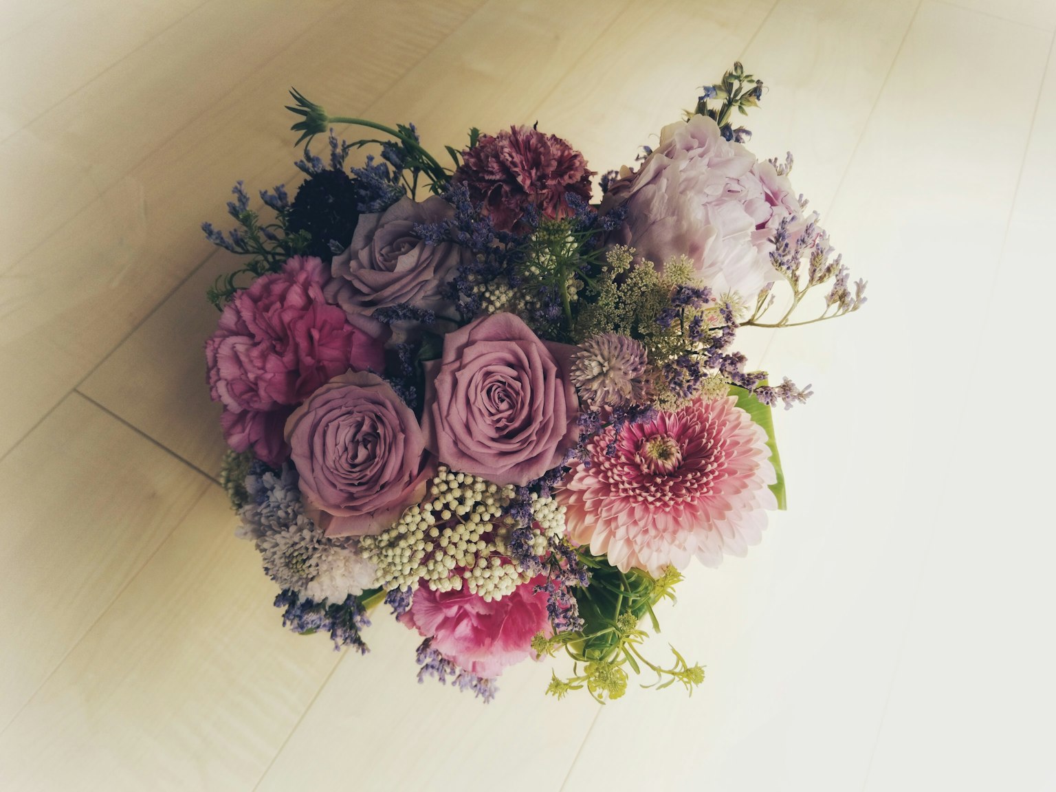 Un beau bouquet de fleurs violettes comprenant des roses, des dahlias et d'autres fleurs