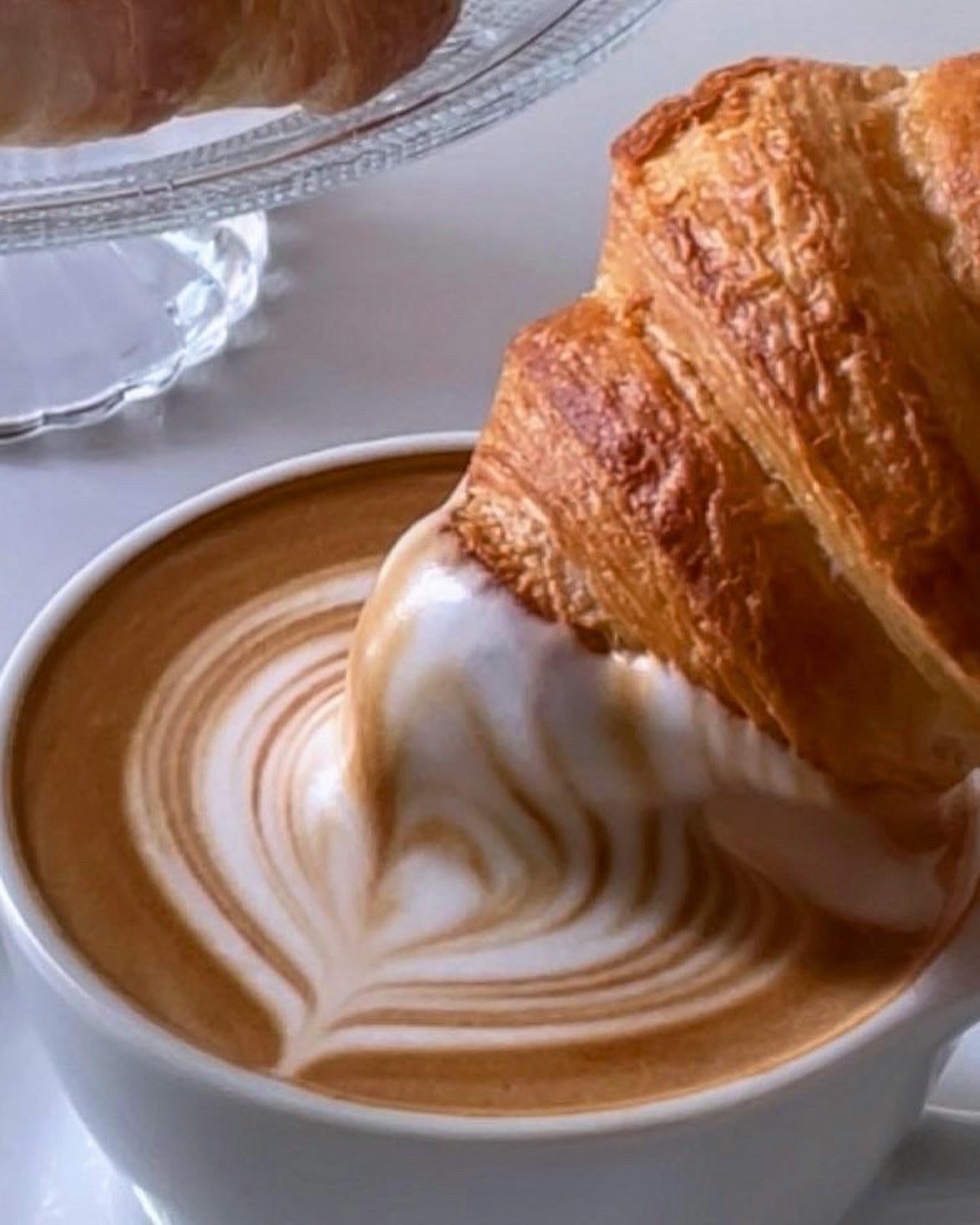 Croissant immerso nel caffè con arte del latte