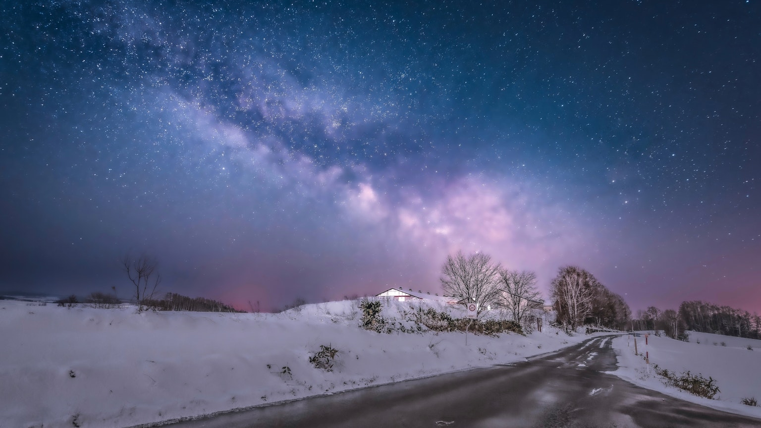 Paysage enneigé avec une route sous un ciel étoilé