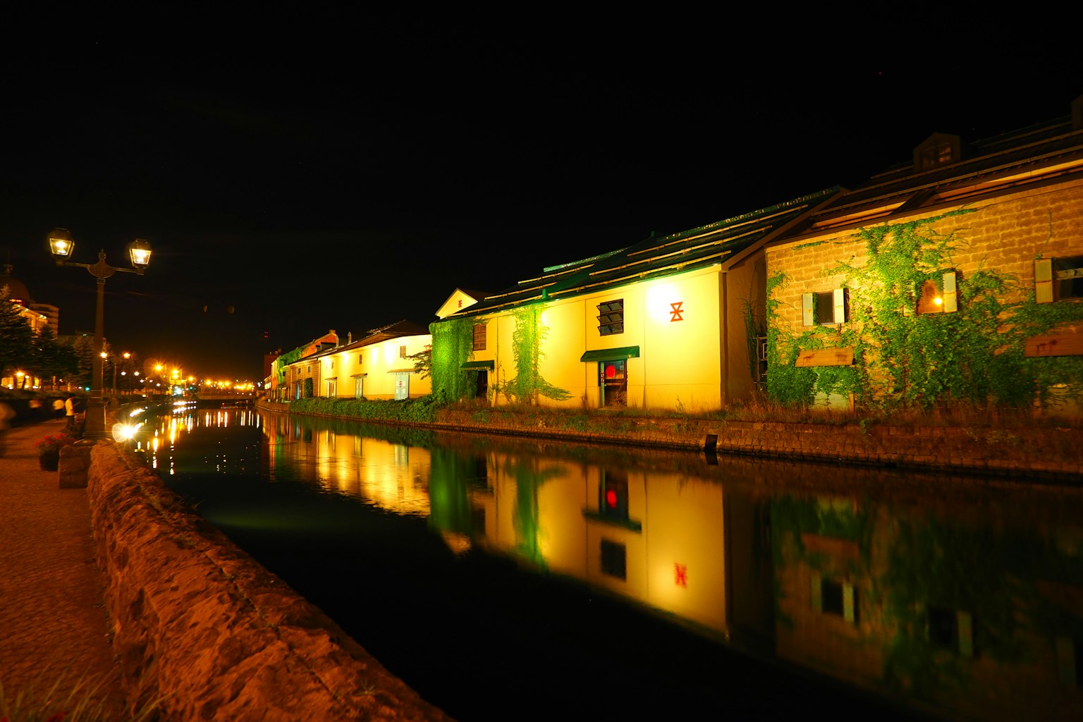 Nighttime riverside scene with old buildings reflecting on the water