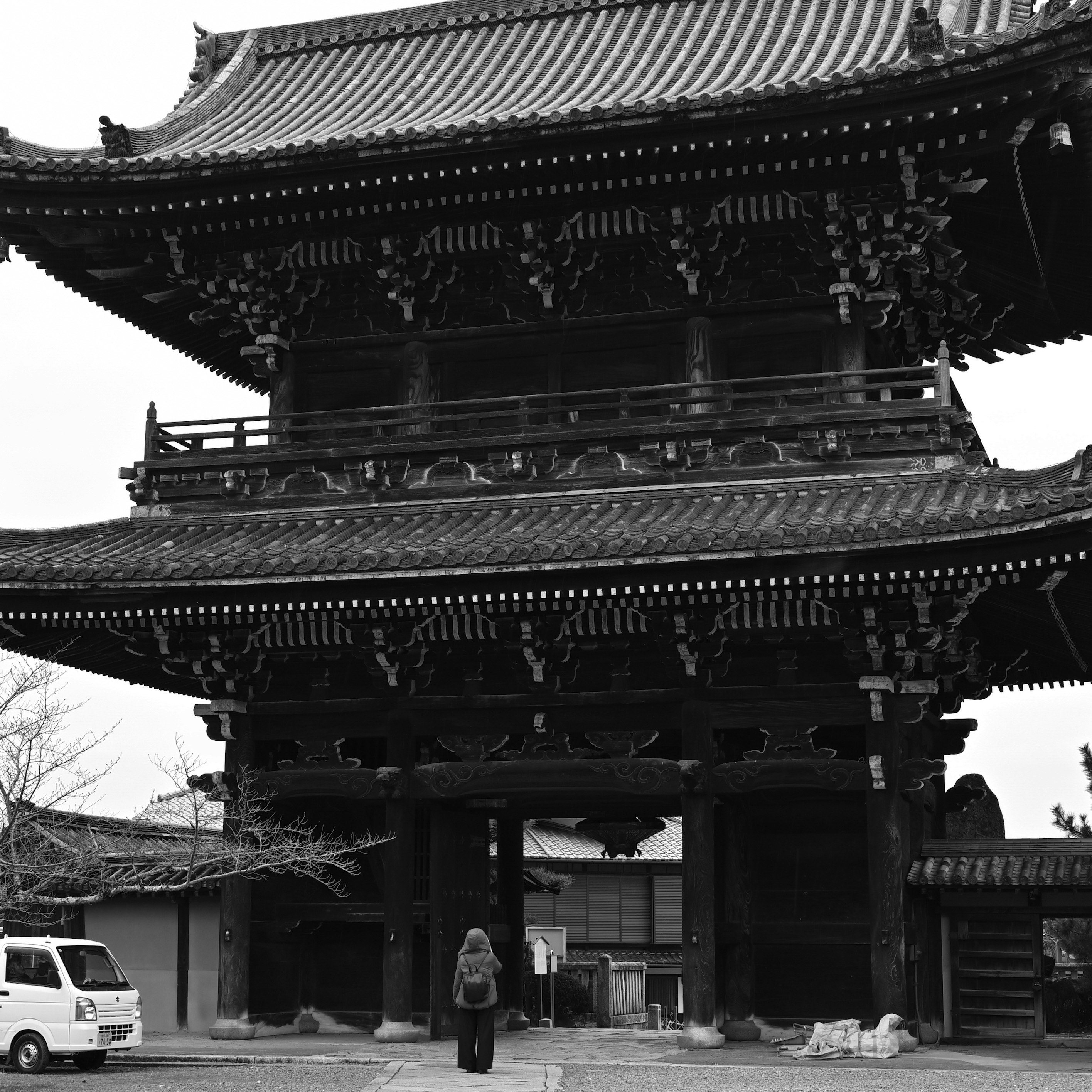 京都の山門（仁王門）前の軽トラと後ろ姿の人物