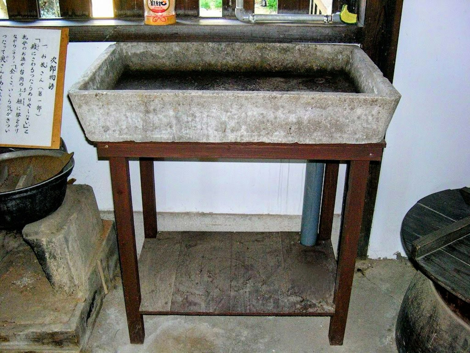 Un lavandino in pietra con gambe di legno è visibile