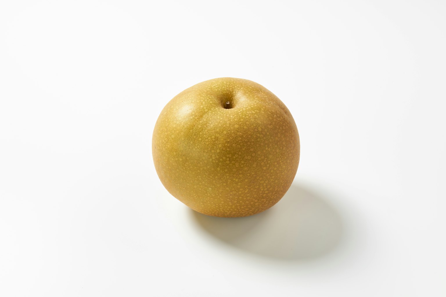 Un fruit jaune rond sur un fond blanc