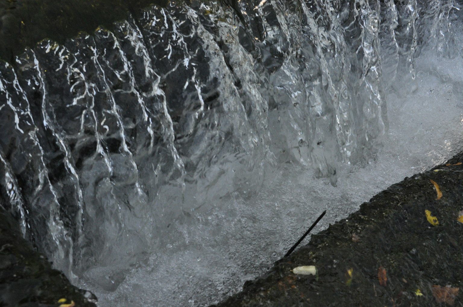Primo piano di una piccola cascata con acqua che scorre e bolle