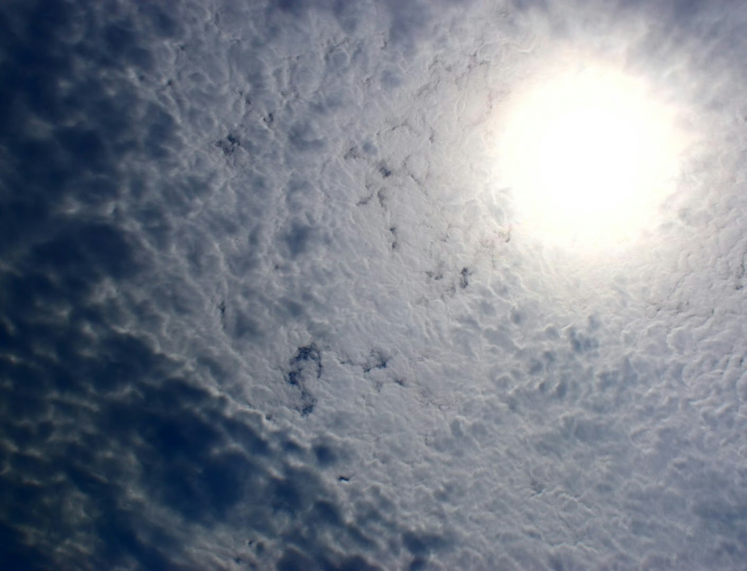 Sol brillante rodeado de nubes en espiral en un cielo azul