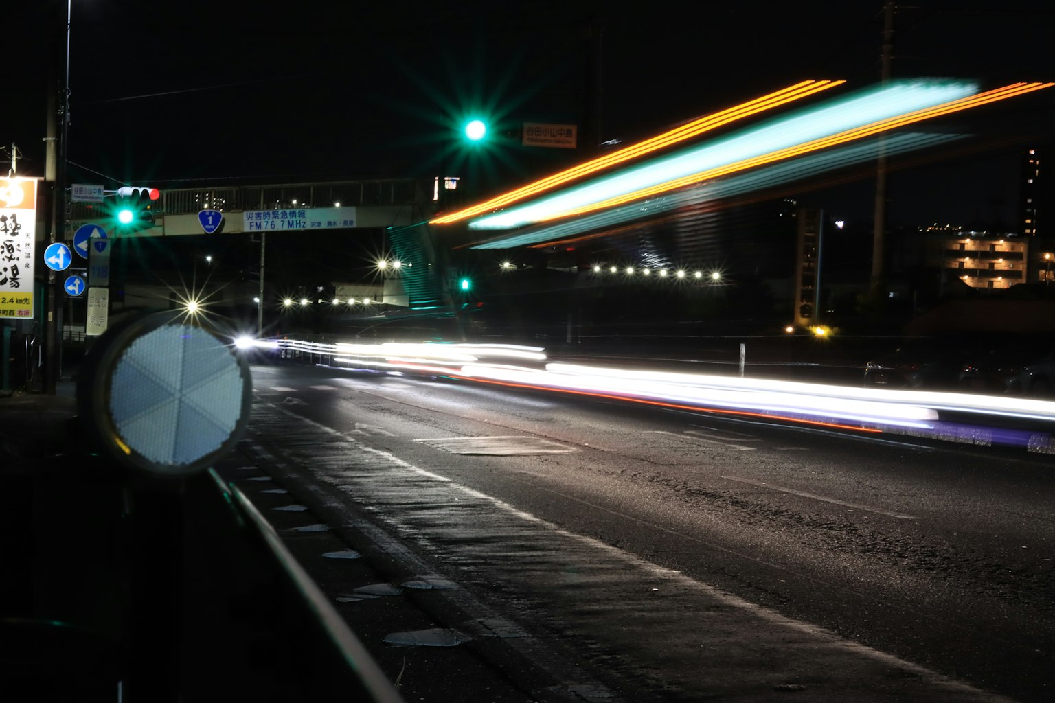Scène nocturne d'une route avec des feux de circulation et des lumières de voiture qui circulent