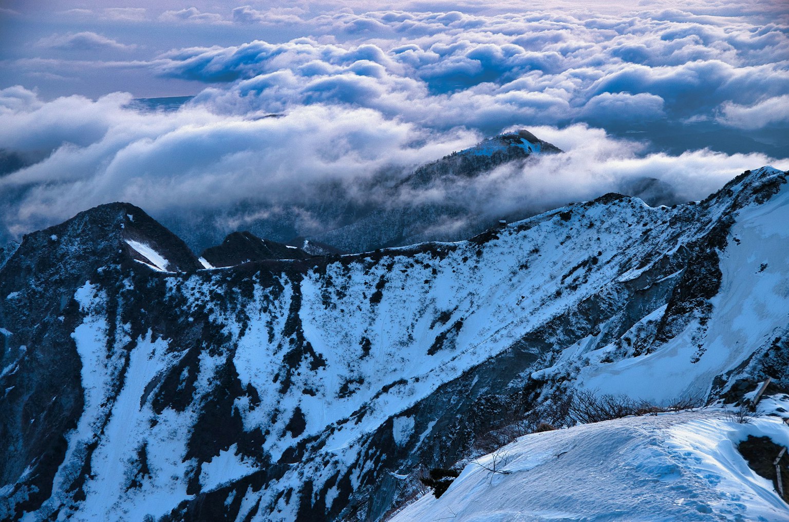 Schneebedeckte Bergkette mit einer Wolkenmeer