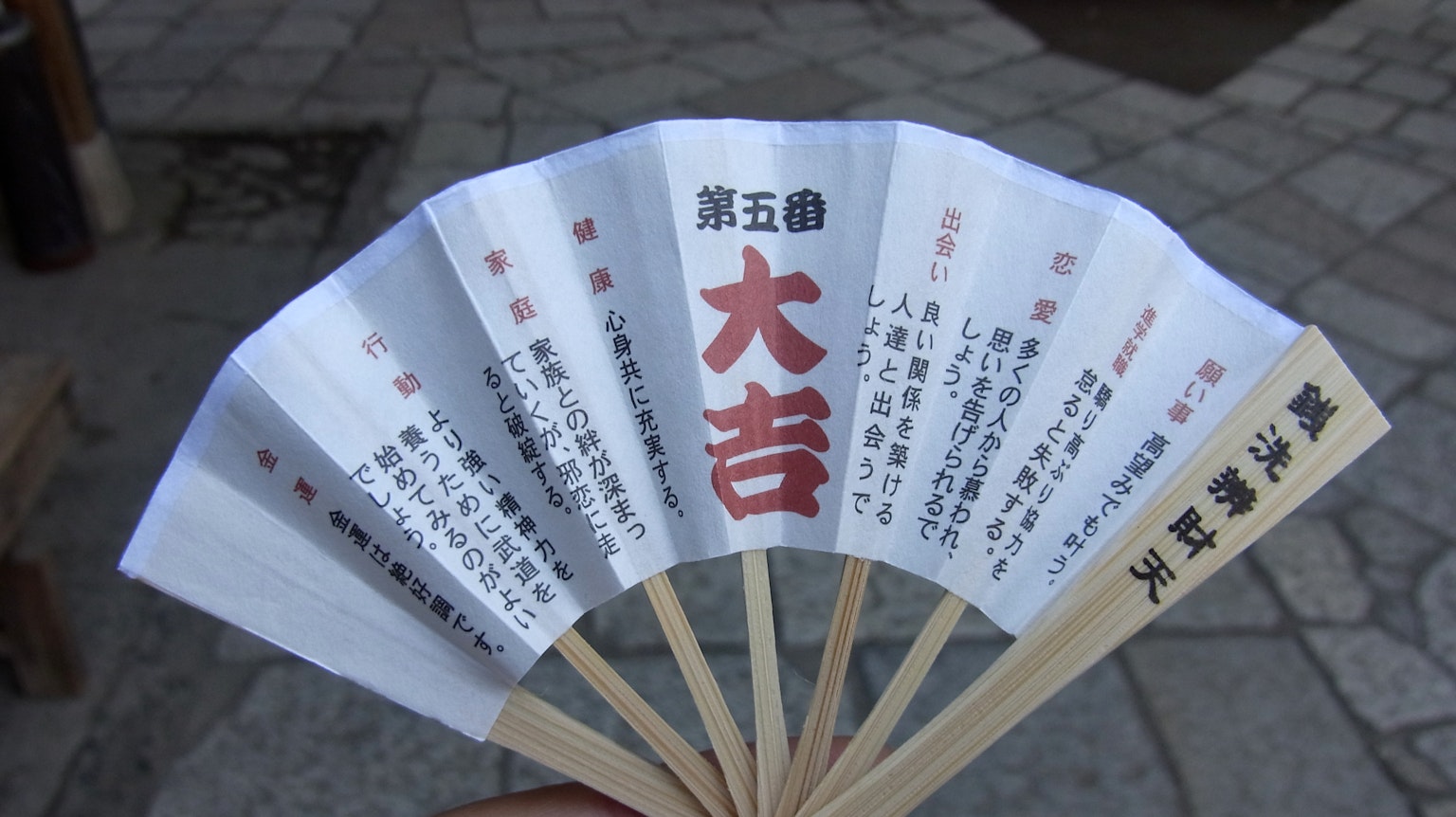 一把扇子上顯示著大吉的字樣和周圍的日文文本