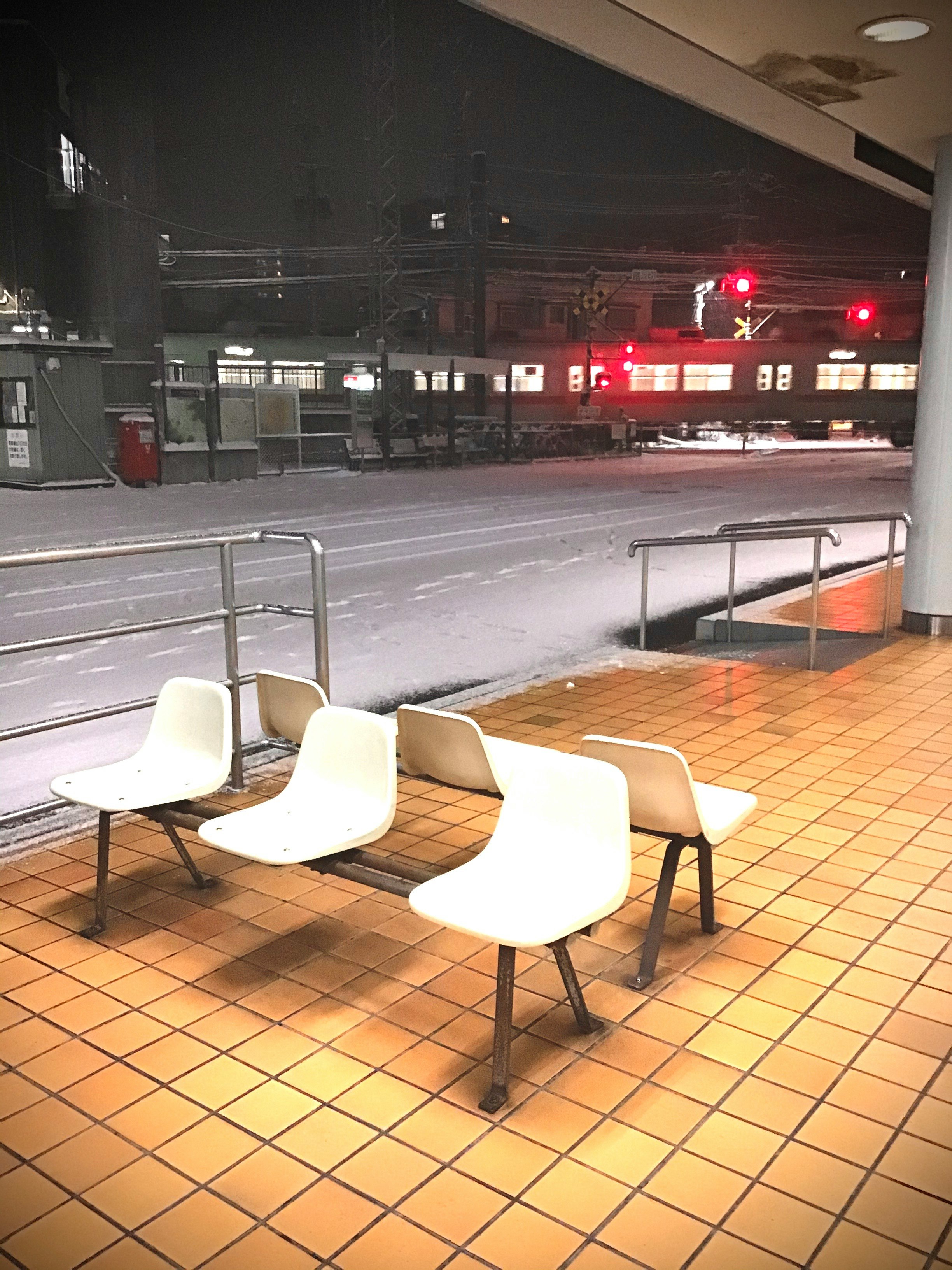 駅のホームに並ぶベンチと線路の夜景