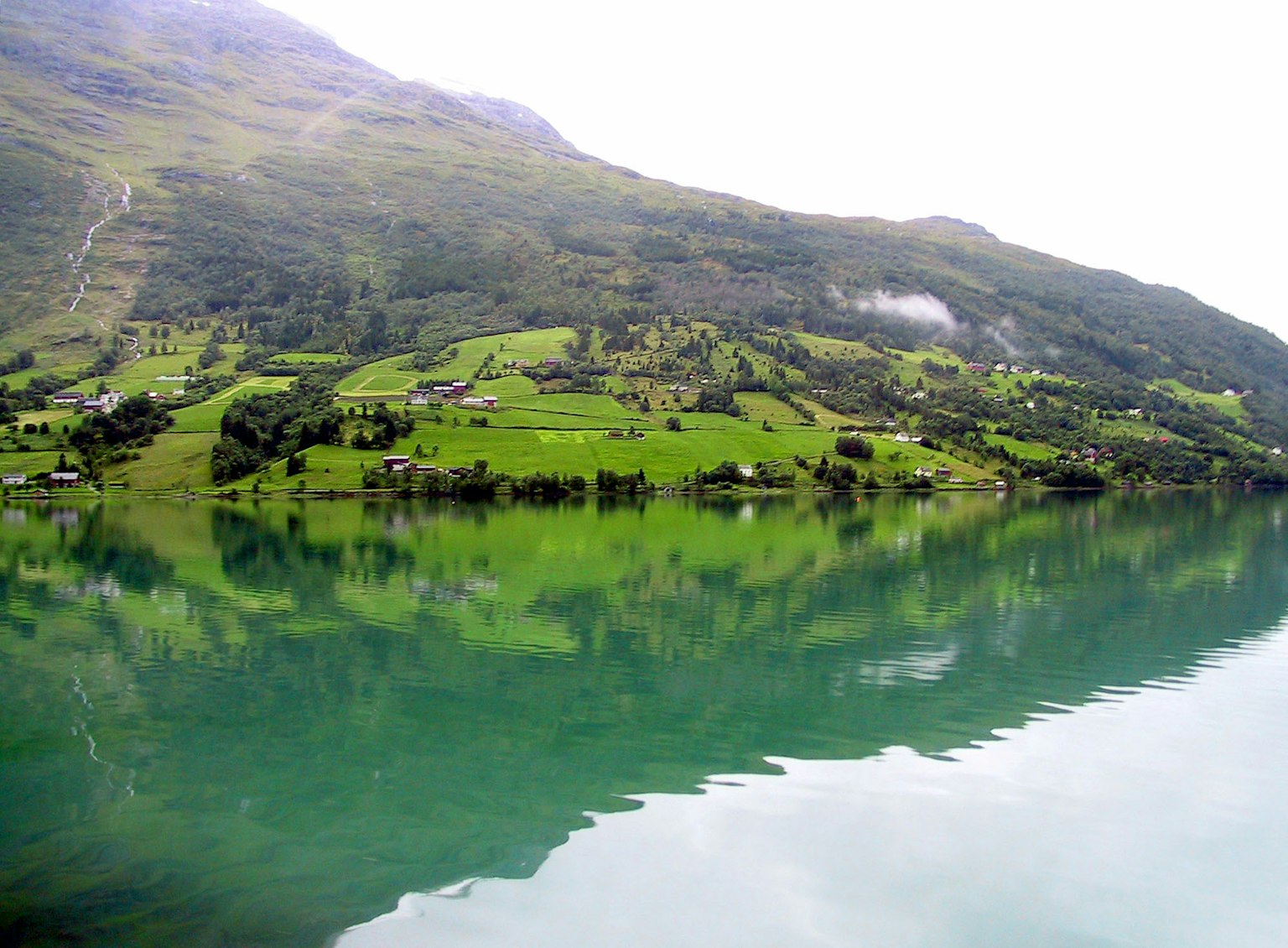 Hermoso paisaje de montañas verdes y reflejos en el agua
